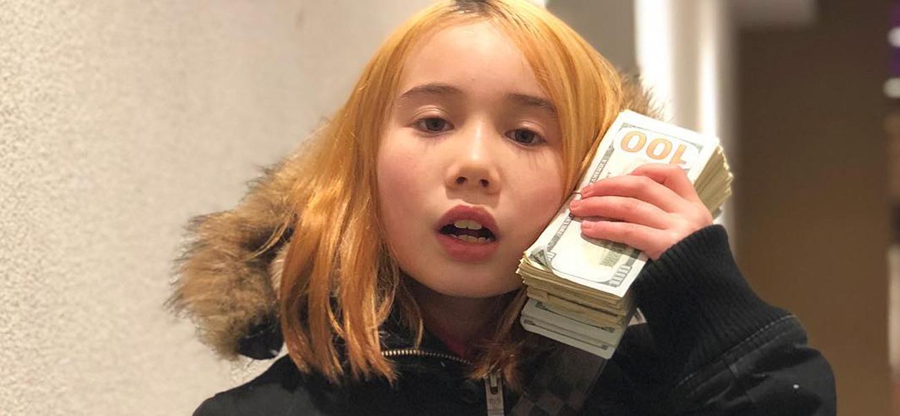 Lil Tay holding a lot of cash to her ear