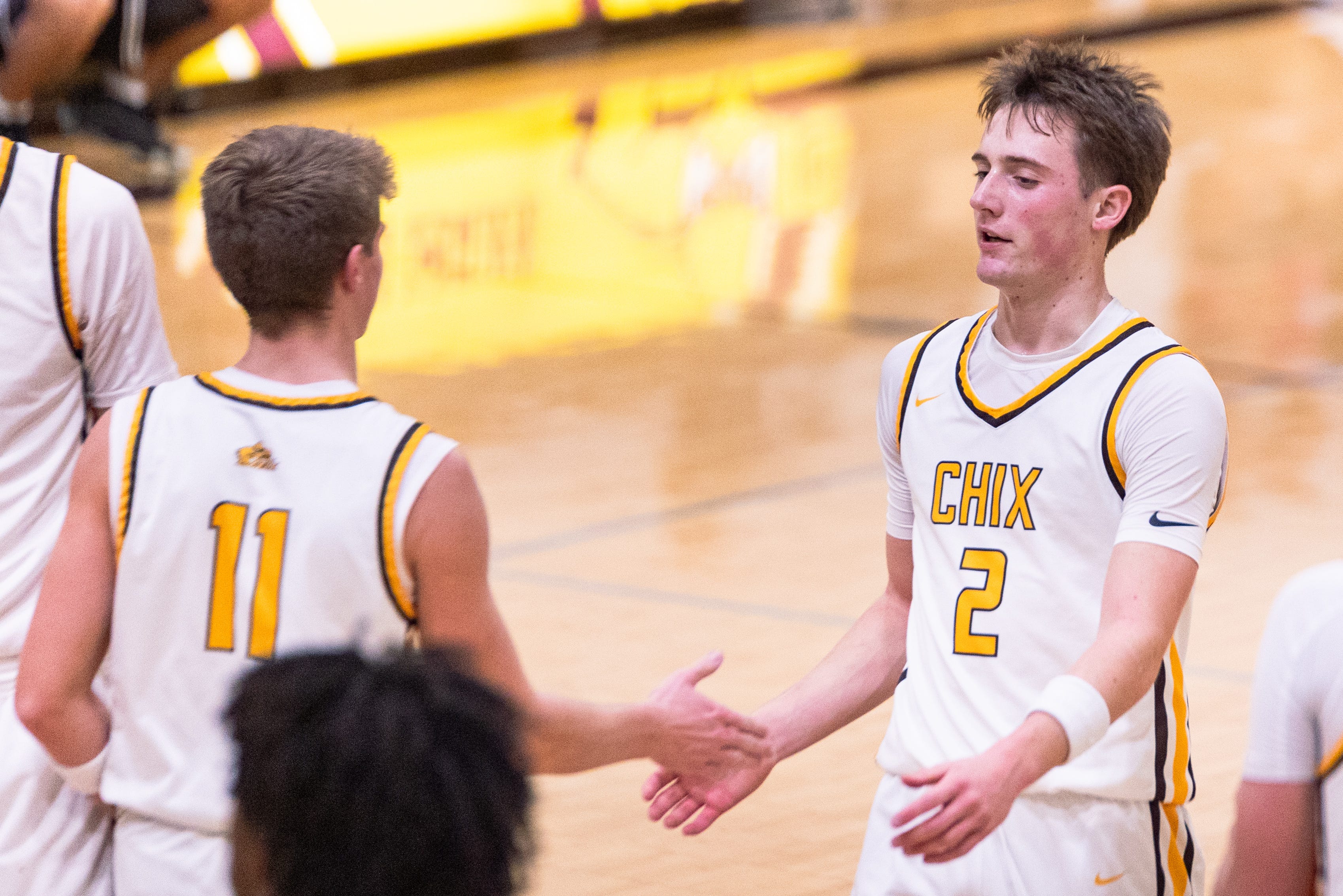 Zeeland East's Will Drnek (right) high fives Isaiah Boonstra (left) during a timeout as they play West Ottawa on Tuesday, Dec. 9.