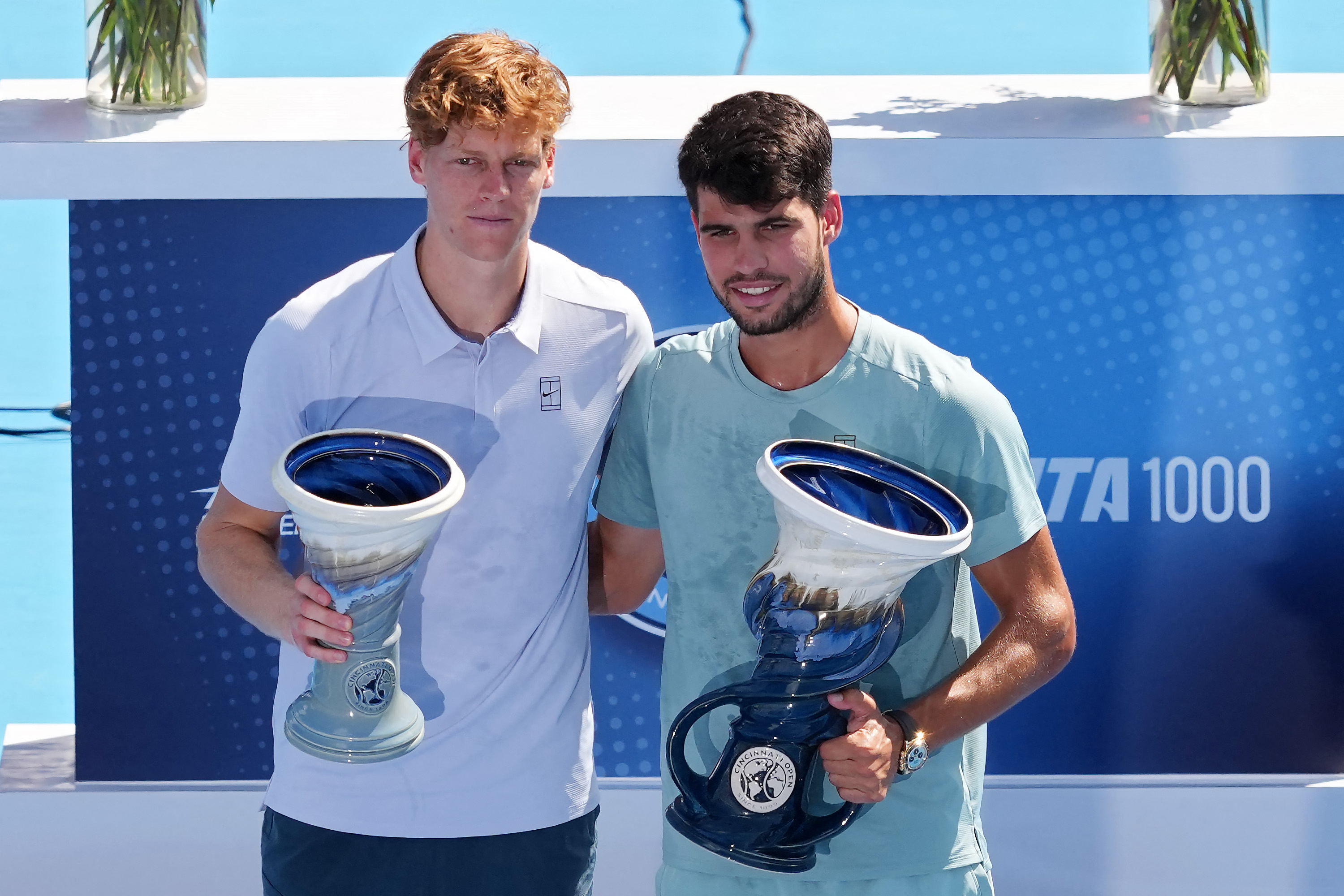 MASON, OHIO - AUGUST 18: Jannik Sinner of Italy (L) and Carlos Alcaraz of Spain pose for photos with the Rookwood Cups after Sinner retired from the men's singles final match during Day 12 of the Cincinnati Open at the Lindner Family Tennis Center on August 18, 2025 in Mason, Ohio. Dylan Buell/Getty Images/AFP (Photo by Dylan Buell / GETTY IMAGES NORTH AMERICA / Getty Images via AFP)