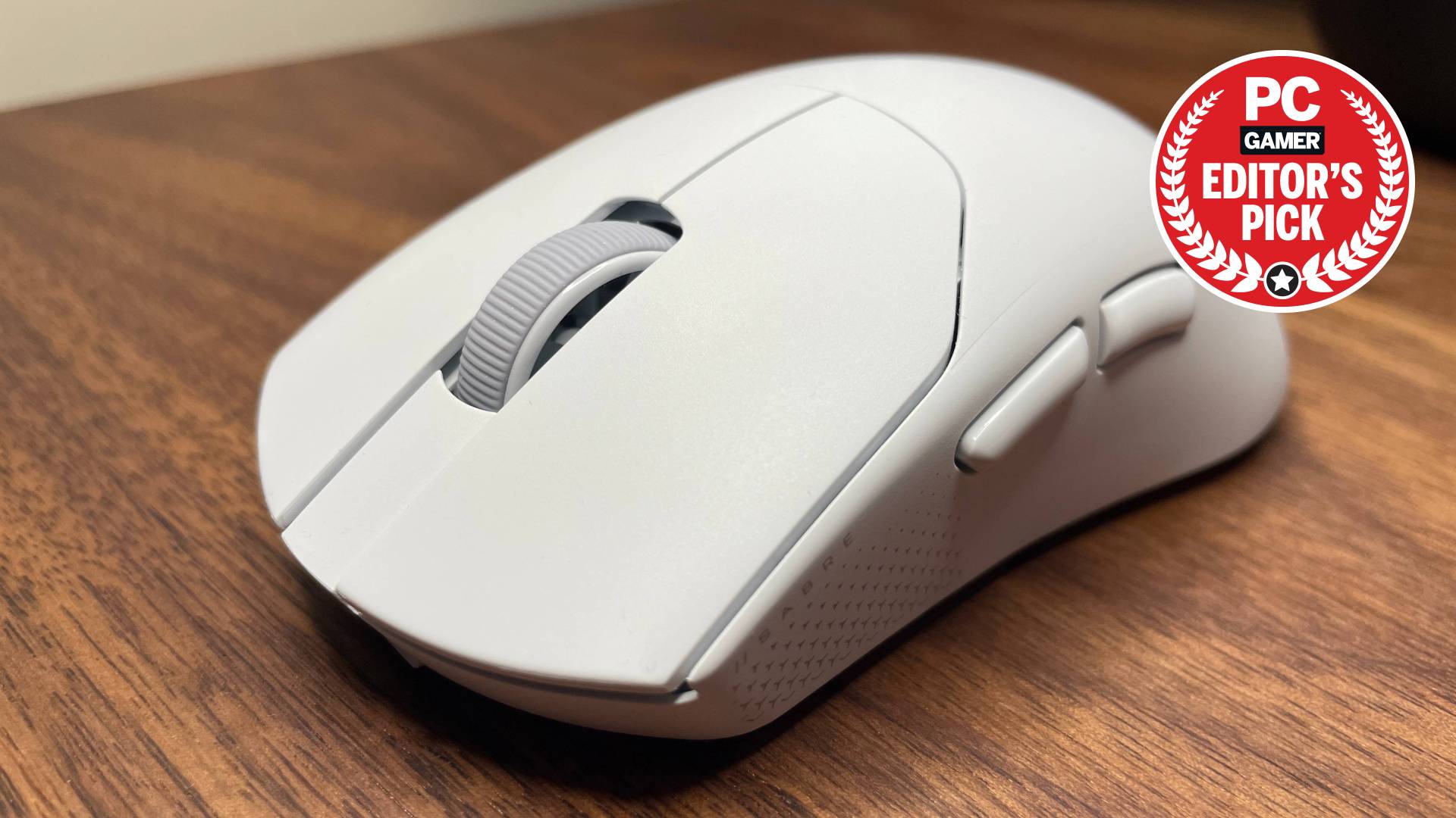 A white Corsair Sabre V2 Pro gaming mouse on top of a desk with a PC Gamer Editor's Pick label on top