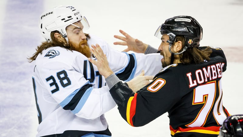 Utah Mammoth's Liam O'Brien, left, and Calgary Flames' Ryan Lomberg fight during the second period of an NHL hockey game in Calgary on Saturday, Dec. 6, 2025. (Jeff McIntosh/The Canadian Press via AP)