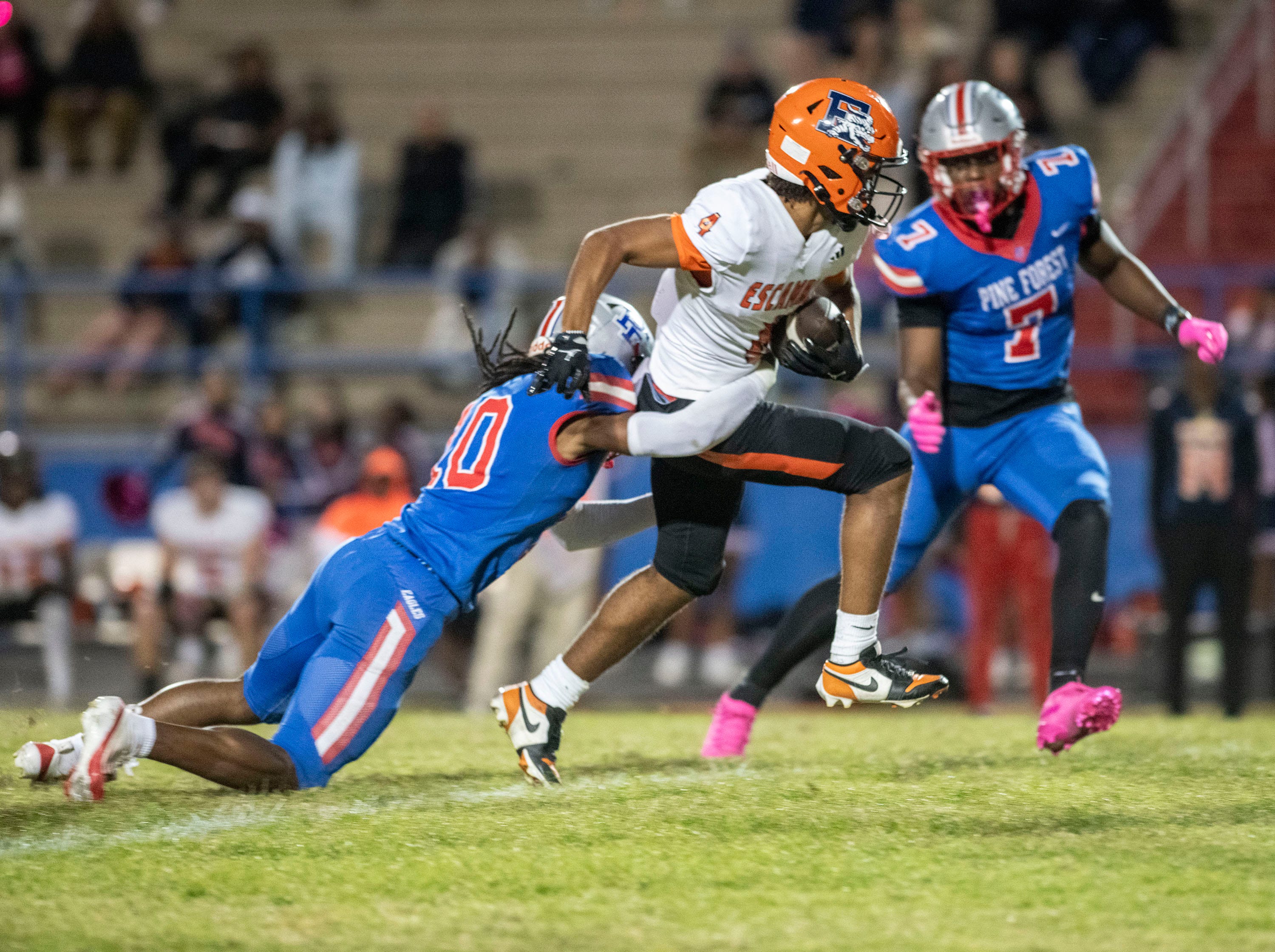 Escambia's Cashon Downs (No. 4) outruns Pine Forest defender Tristain Henderson (No. 20) while defensive end Trent Henderson (No. 7) closes in during Friday night's District 1-4A gridiron matchup.