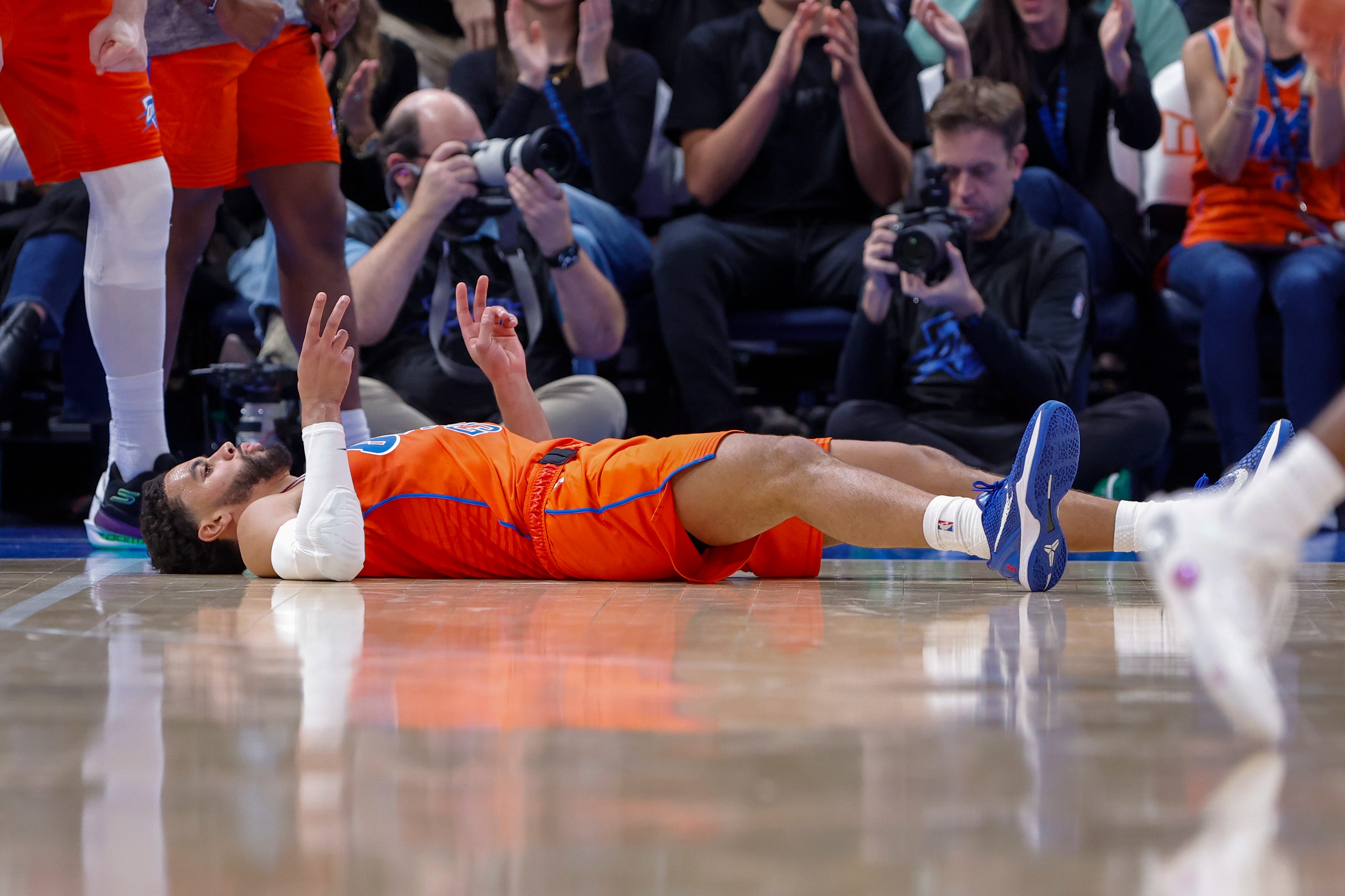 Nov 11, 2025; Oklahoma City, Oklahoma, USA; Oklahoma City Thunder guard Ajay Mitchell (25) gestures as he lays on the court after scoring against the Golden State Warriors during the second half at Paycom Center. Mandatory Credit: Alonzo Adams-Imagn Images