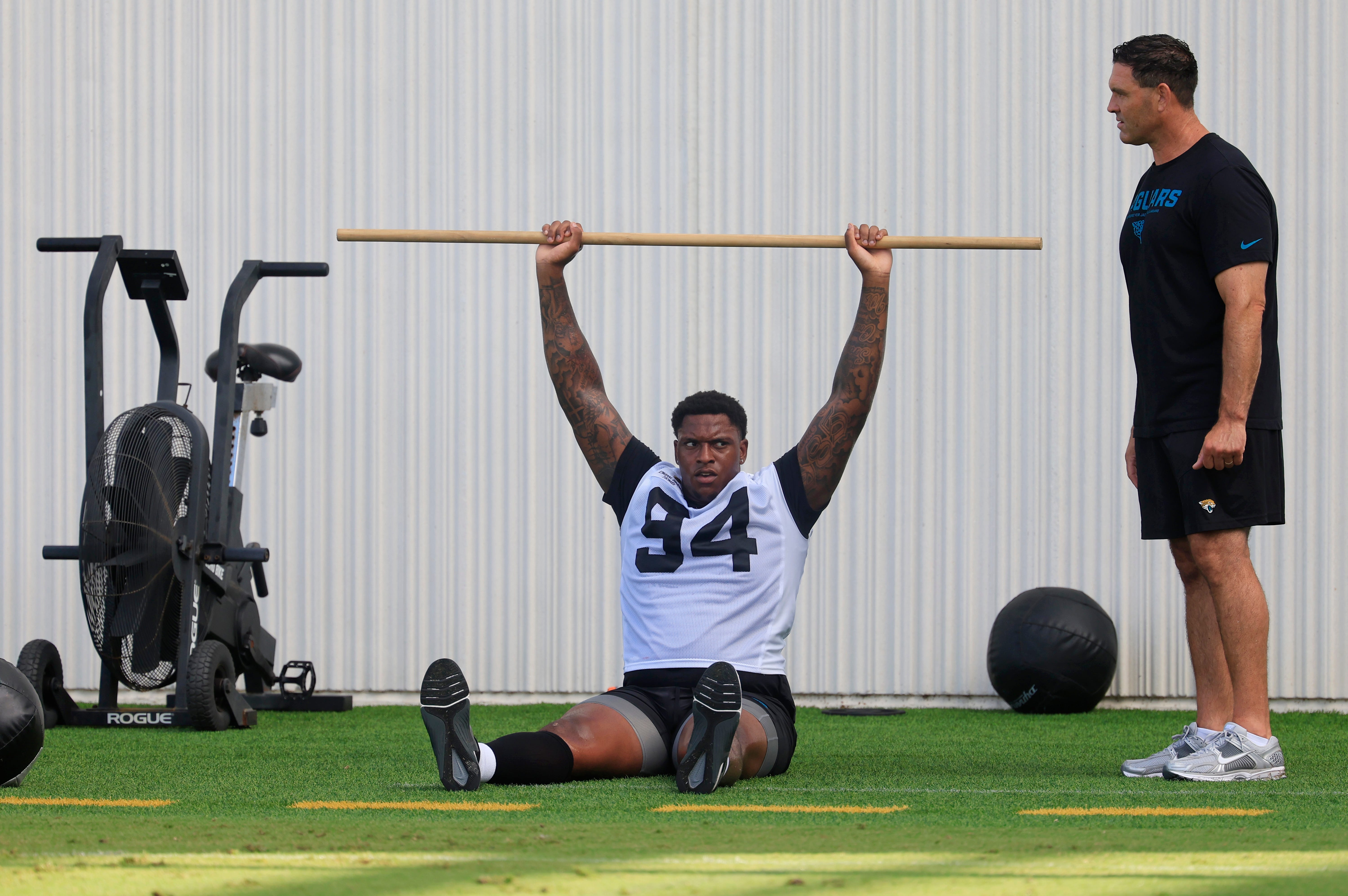 Jacksonville Jaguars defensive tackle Maason Smith (94) works out as Eric Ciano, Director of strength and conditioning, looks on during an NFL training camp session at the Miller Electric Center, Friday, July 25, 2025, in Jacksonville, Fla.