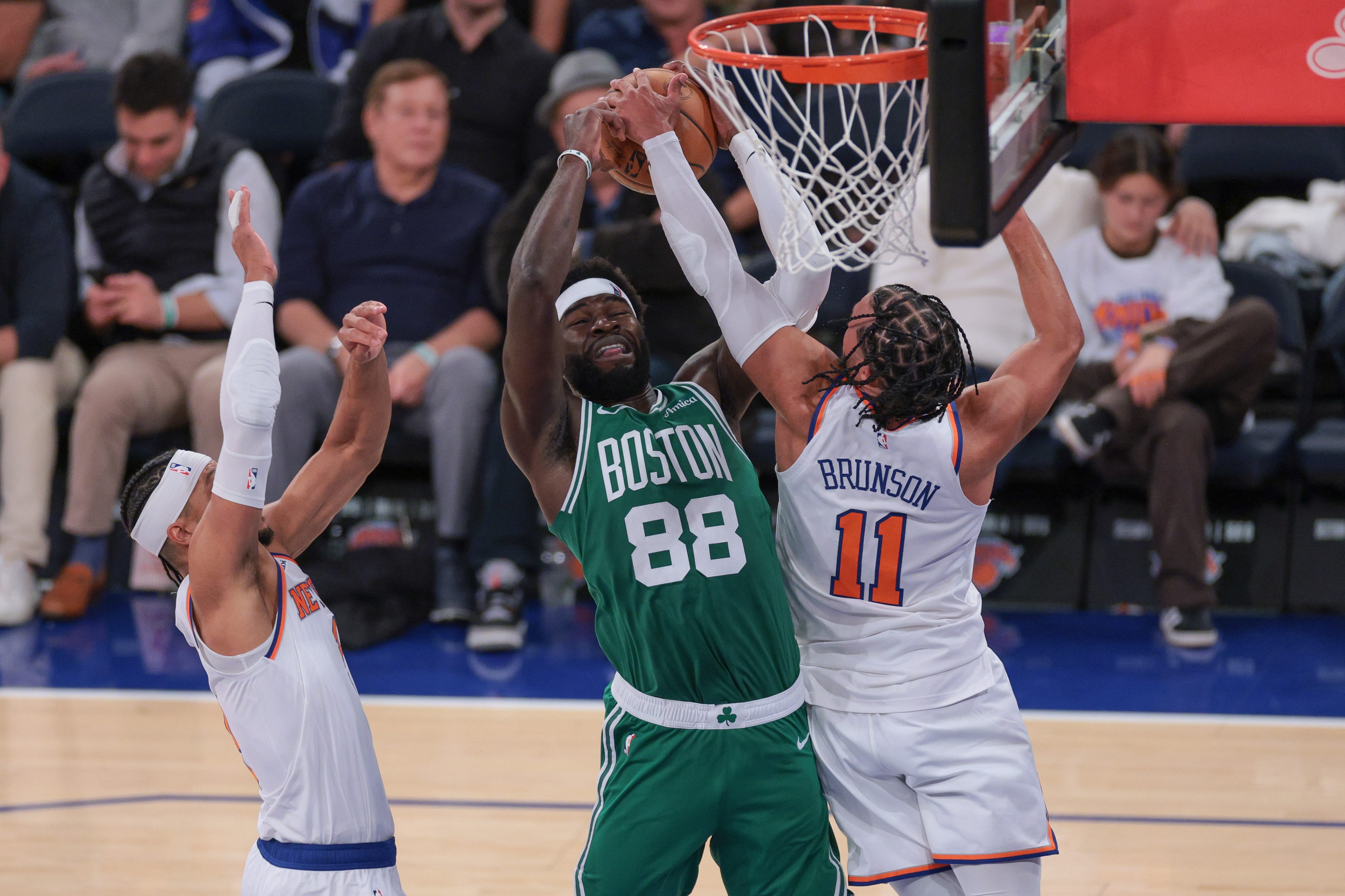 Oct 24, 2025; New York, New York, USA; Boston Celtics center Neemias Queta (88) rebounds against New York Knicks guard Jalen Brunson (11) and guard Josh Hart (3) during the fourth quarter at Madison Square Garden. Mandatory Credit: Vincent Carchietta-Imagn Images