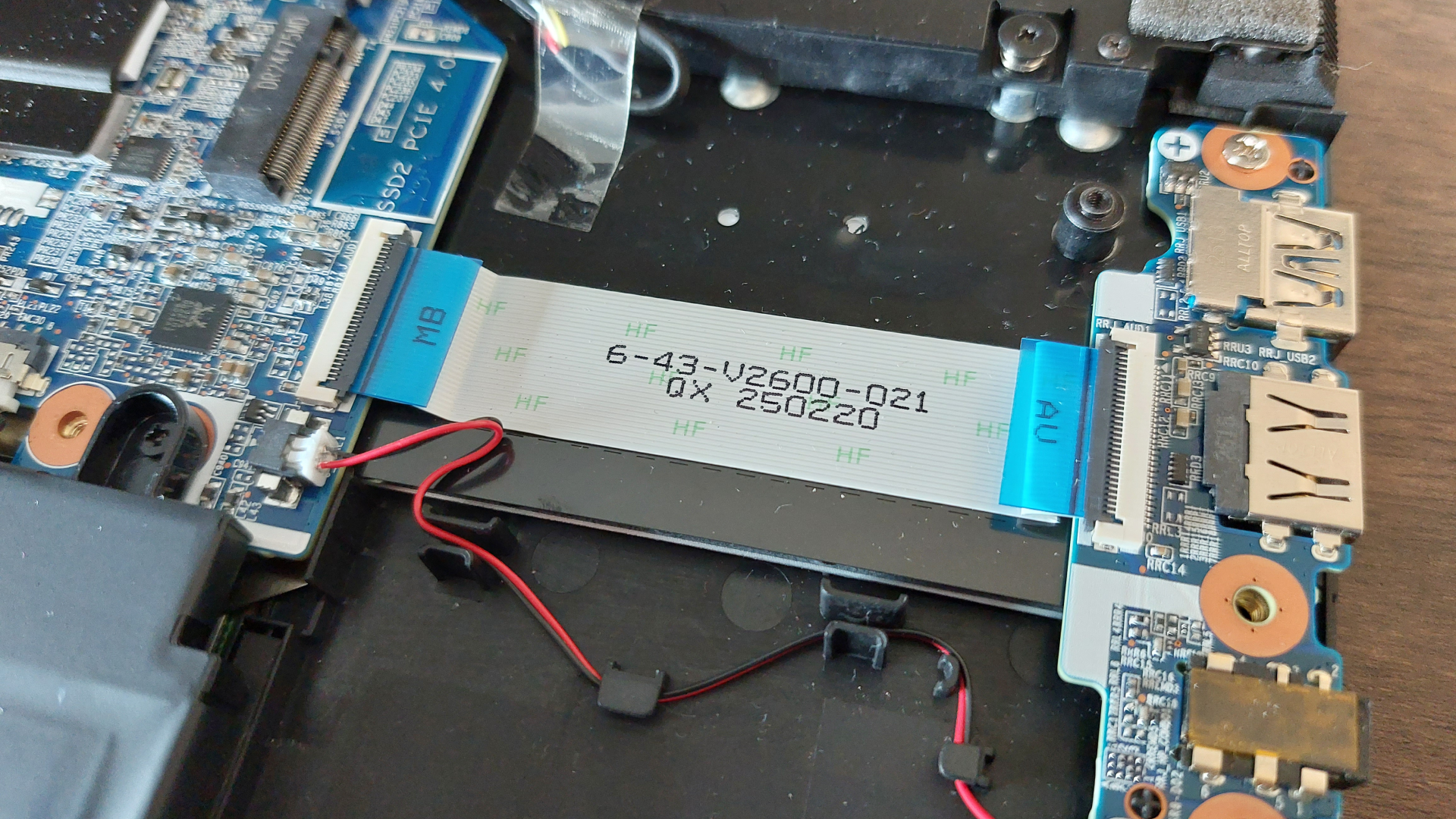 The Erazer Scout 15 E1 RTX 5050 gaming laptop is seen on a wooden desk in a brightly lit, neutral toned office.