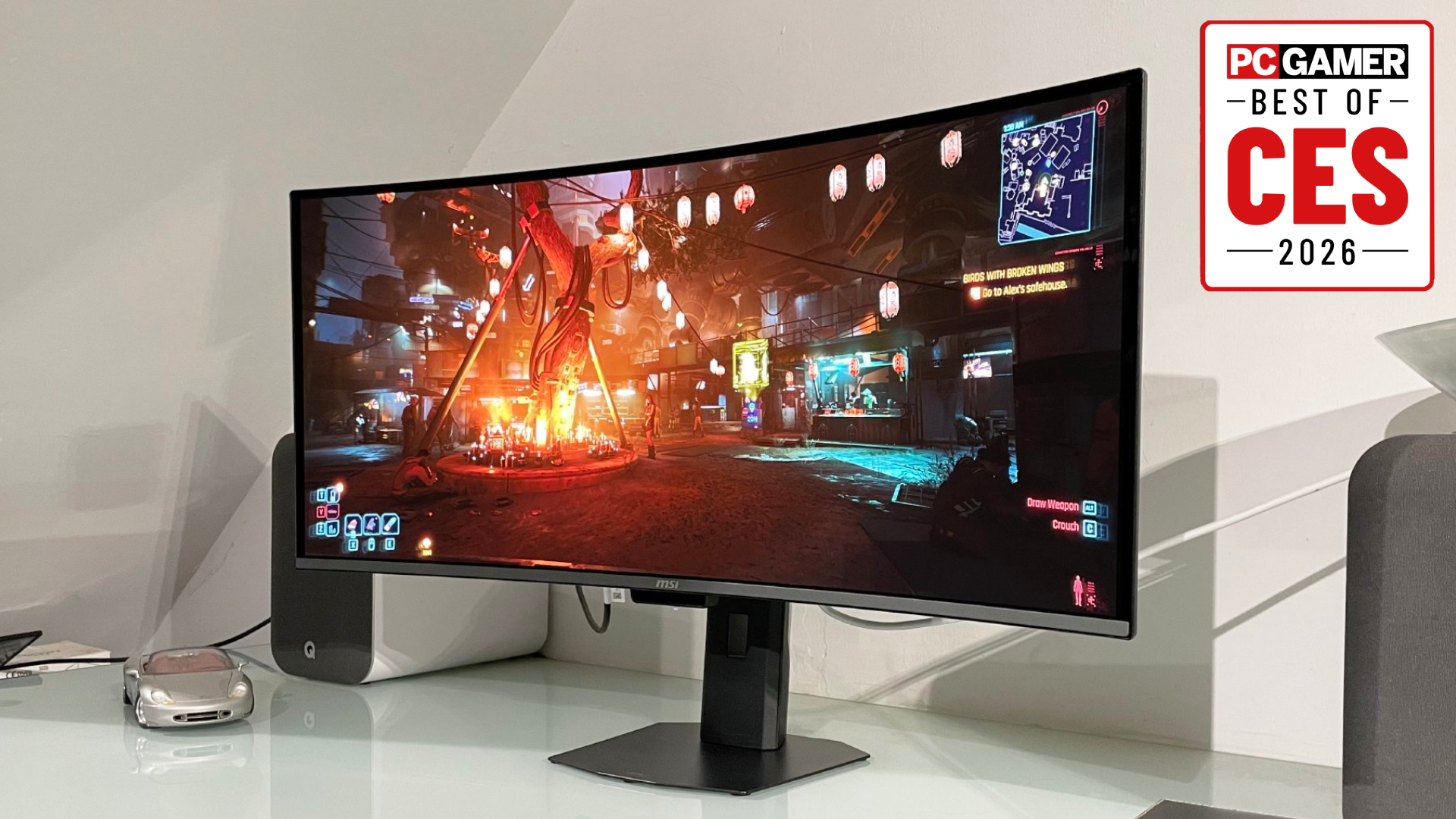 The MSI MPG 341CQR QD-OLED X36 gaming monitor on a desk, with the PC Gamer Best of CES 2026 badge in the top right