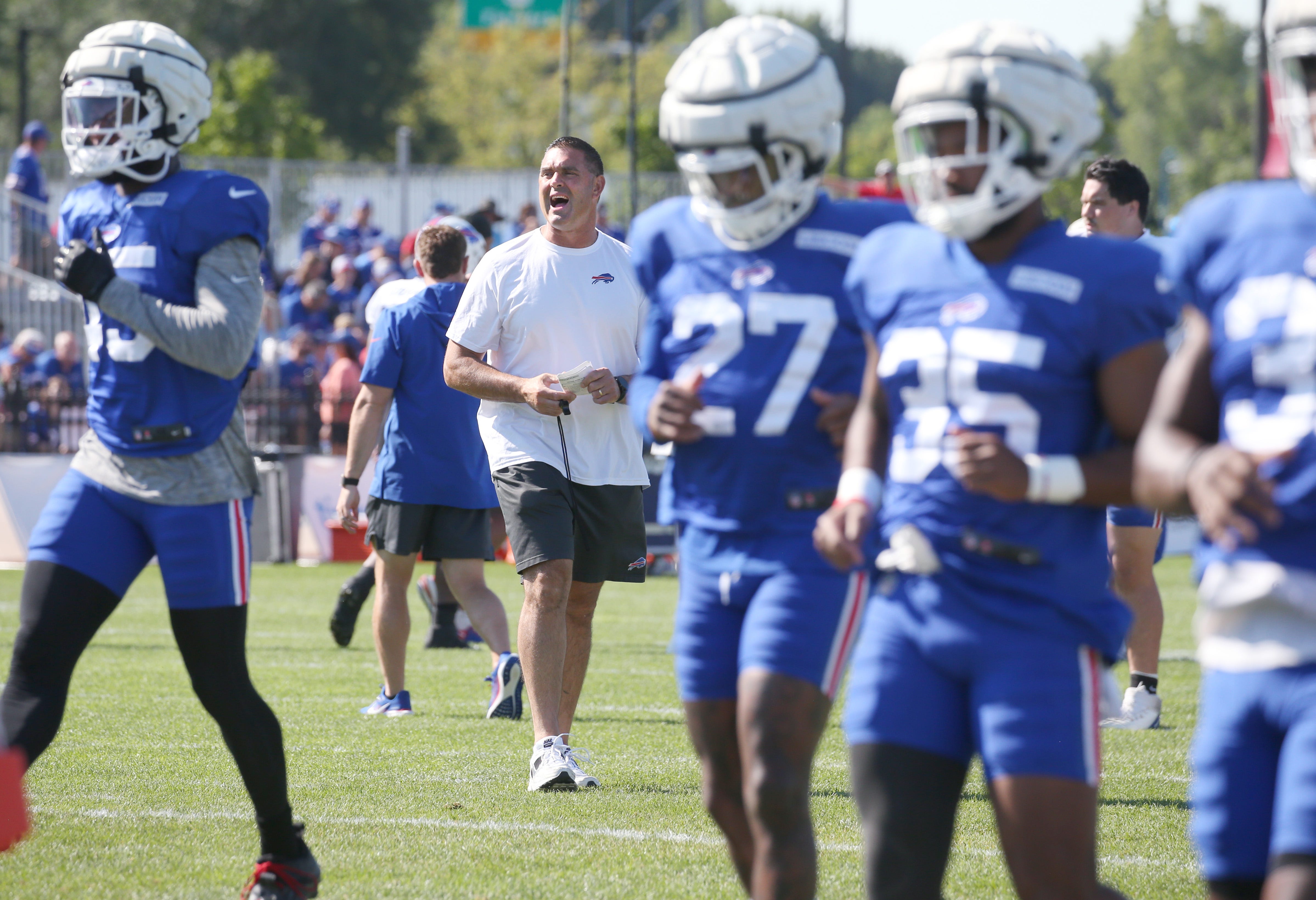 Bills head strength and conditioning coach Eric Ciano calls out the next stretch as the team warms up at the start of training camp.
