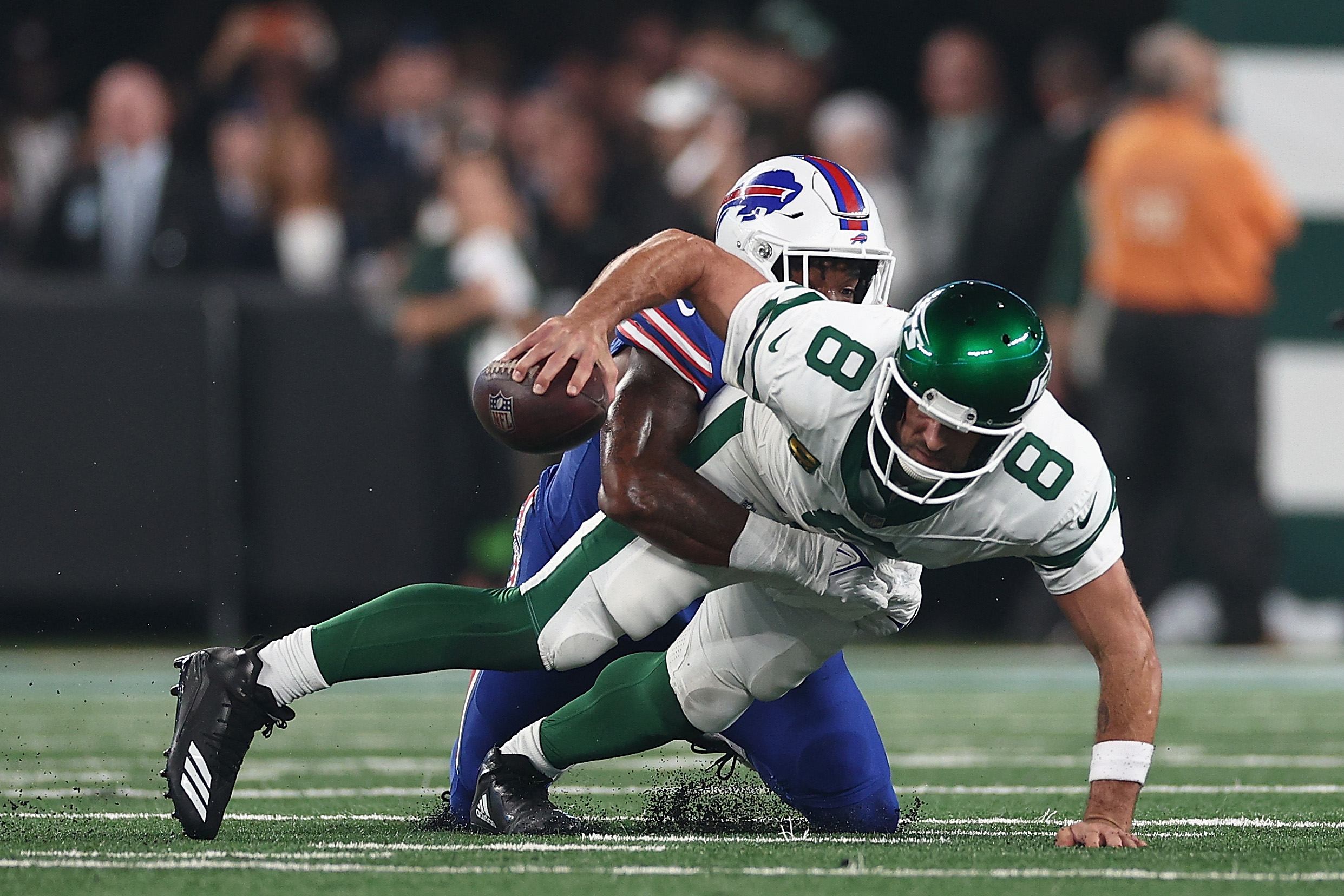 EAST RUTHERFORD, NEW JERSEY - SEPTEMBER 11: Quarterback Aaron Rodgers #8 of the New York Jets sacked by defensive end Leonard Floyd #56 of the Buffalo Bills during the first quarter of the NFL game at MetLife Stadium on September 11, 2023 in East Rutherford, New Jersey. (Photo by Elsa/Getty Images)