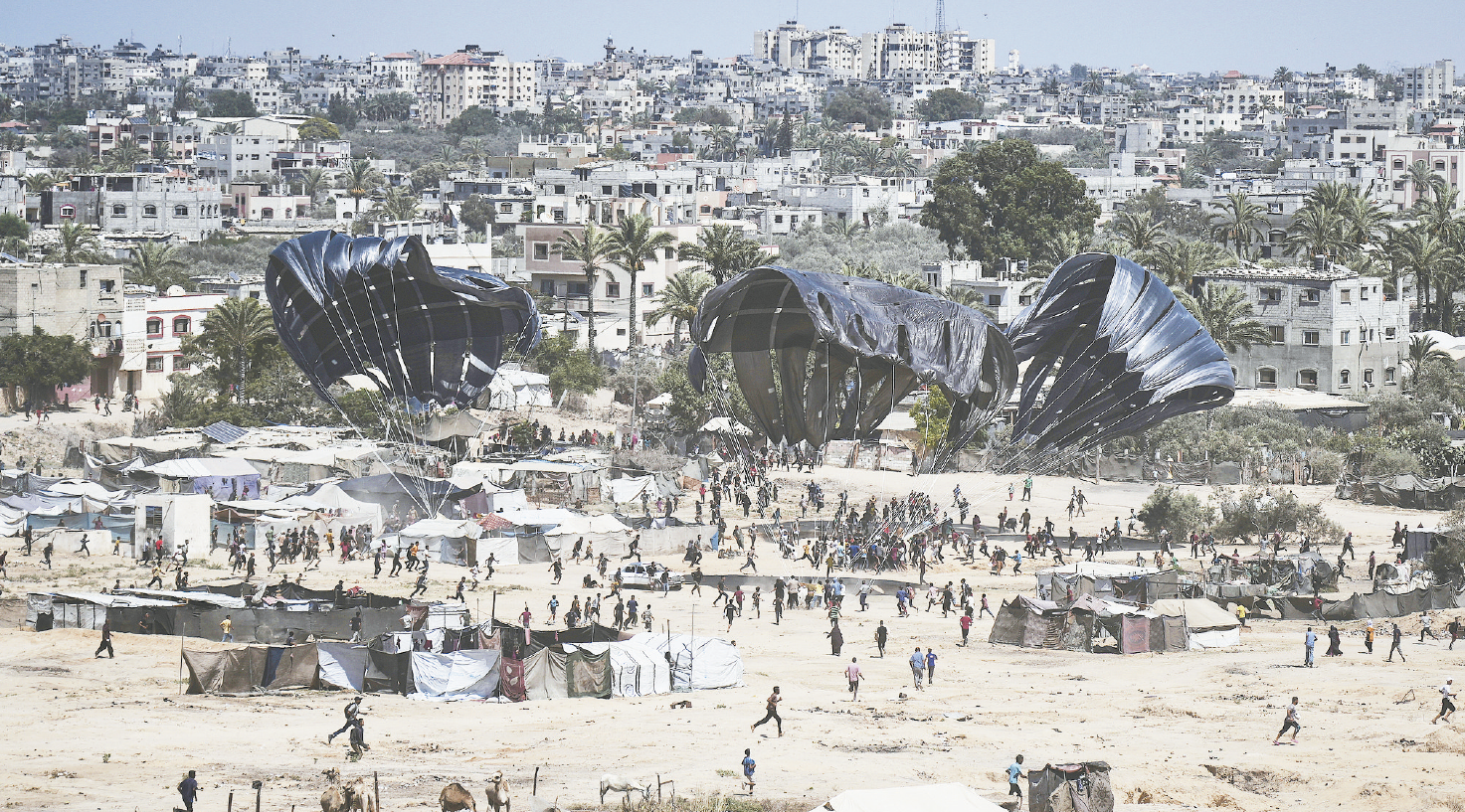 7月31日，生活在加沙地带中部扎韦达的巴勒斯坦人，蜂拥至空投地点，领取人道主义援助物资。（视觉中国）