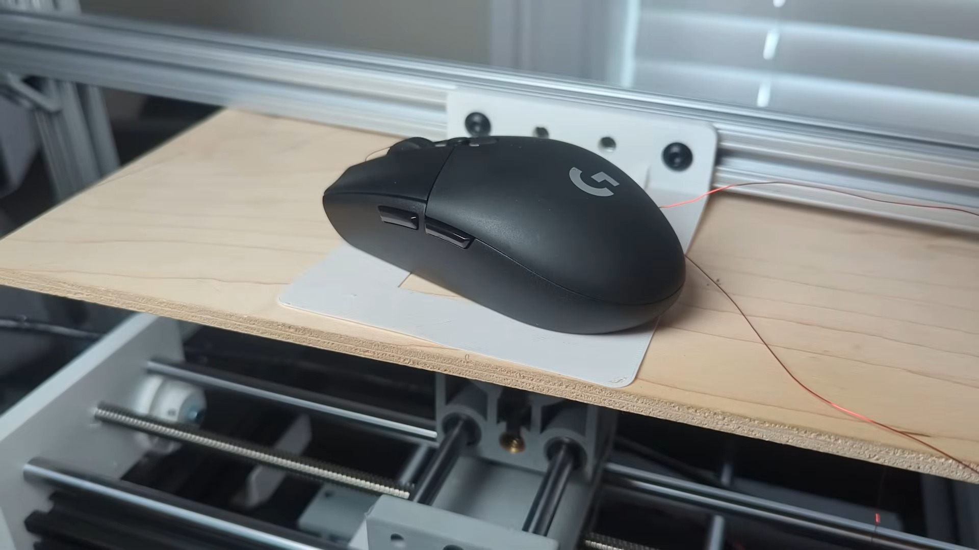 A Logitech gaming mouse atop a physical aimbot device
