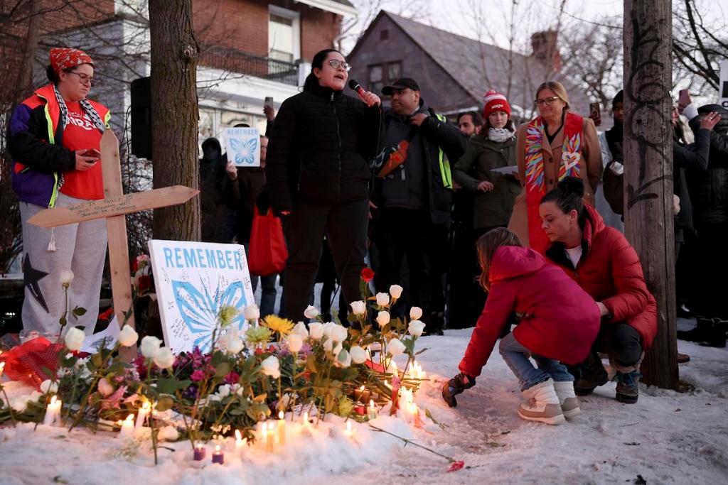 people kneel at a makeshift memorial