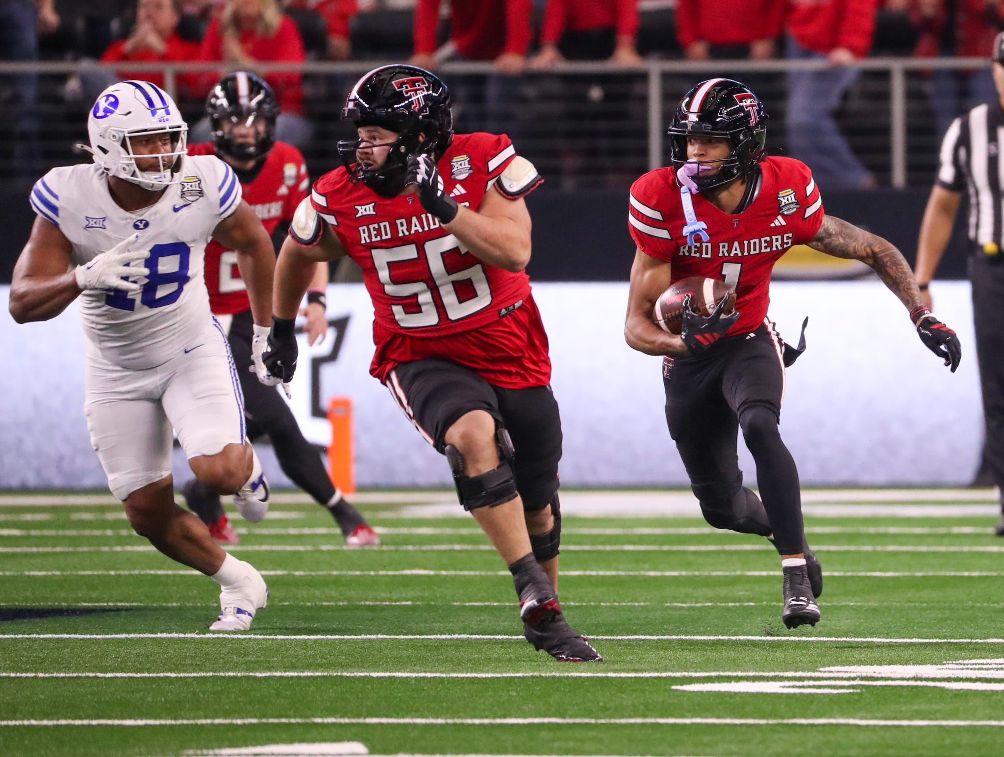 Texas Tech's Reggie Virgil (right) follows a block from Davion Carter on a catch and run against BYU during the Big 12 Conference championship football game, Saturday, Nov. 6, 2025, at AT&T Stadium in Arlington.
