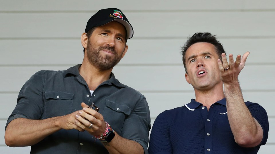 Ryan Reynolds and Rob McElhenney, co-owners of Wrexham AFC, react before a soccer match.