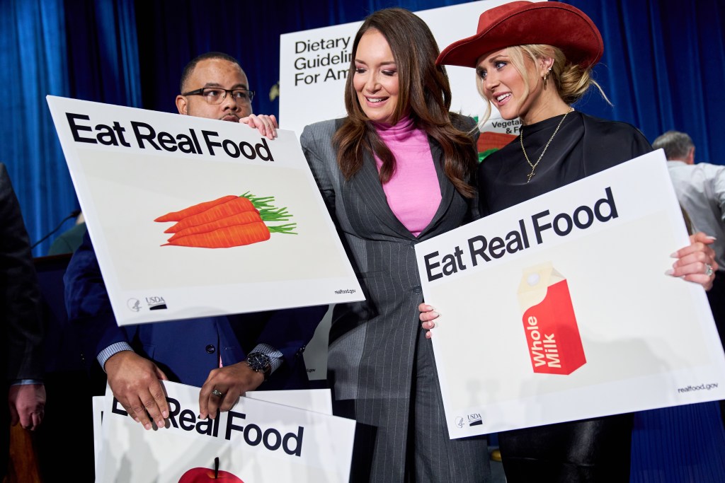 happy people in suits hold signs with carrots and milks on them