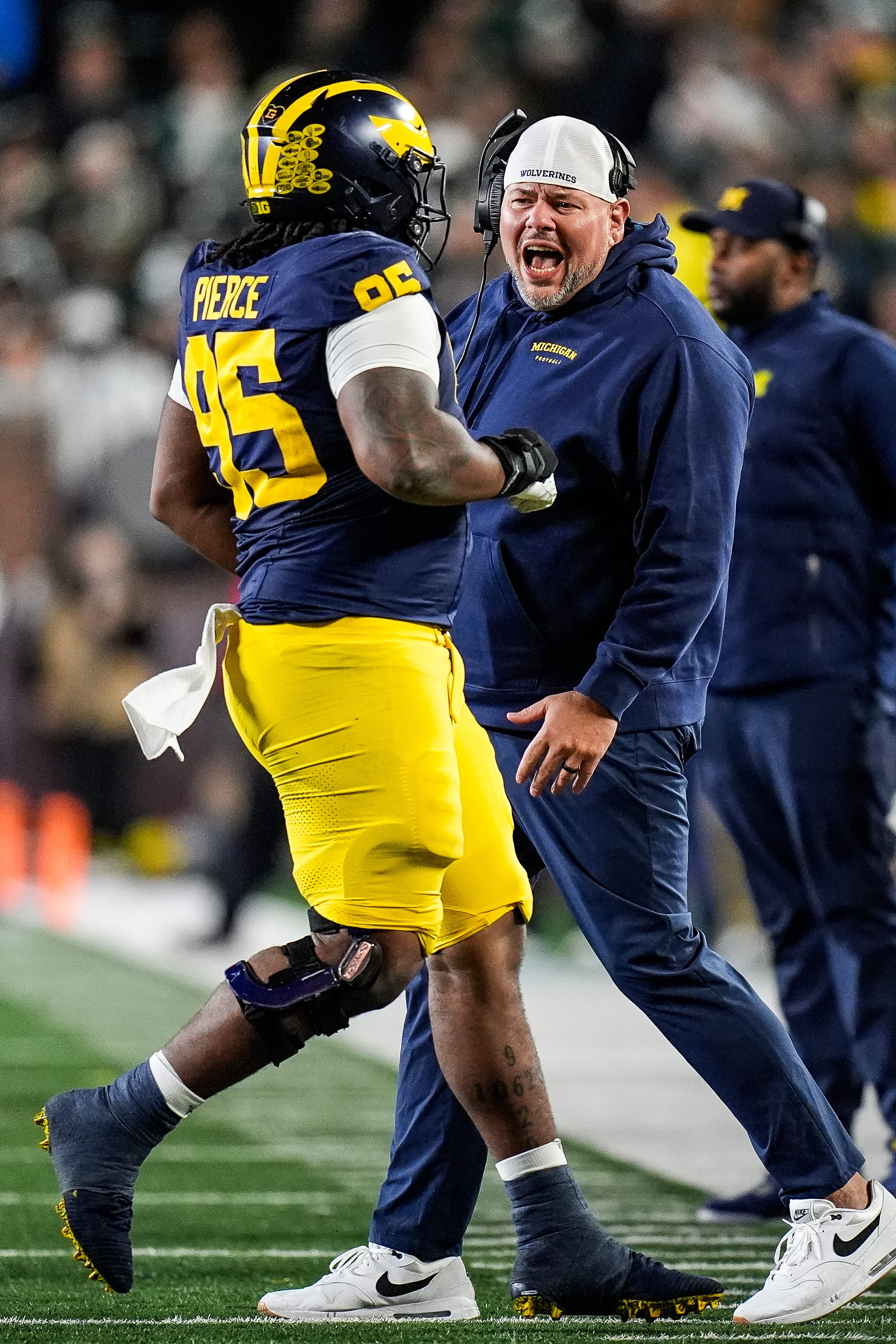 Michigan defensive line coach Lou Esposito talks to defensive lineman Trey Pierce (95) during the second half against Michigan State at Michigan Stadium in Ann Arbor on Saturday, Oct. 26, 2024.