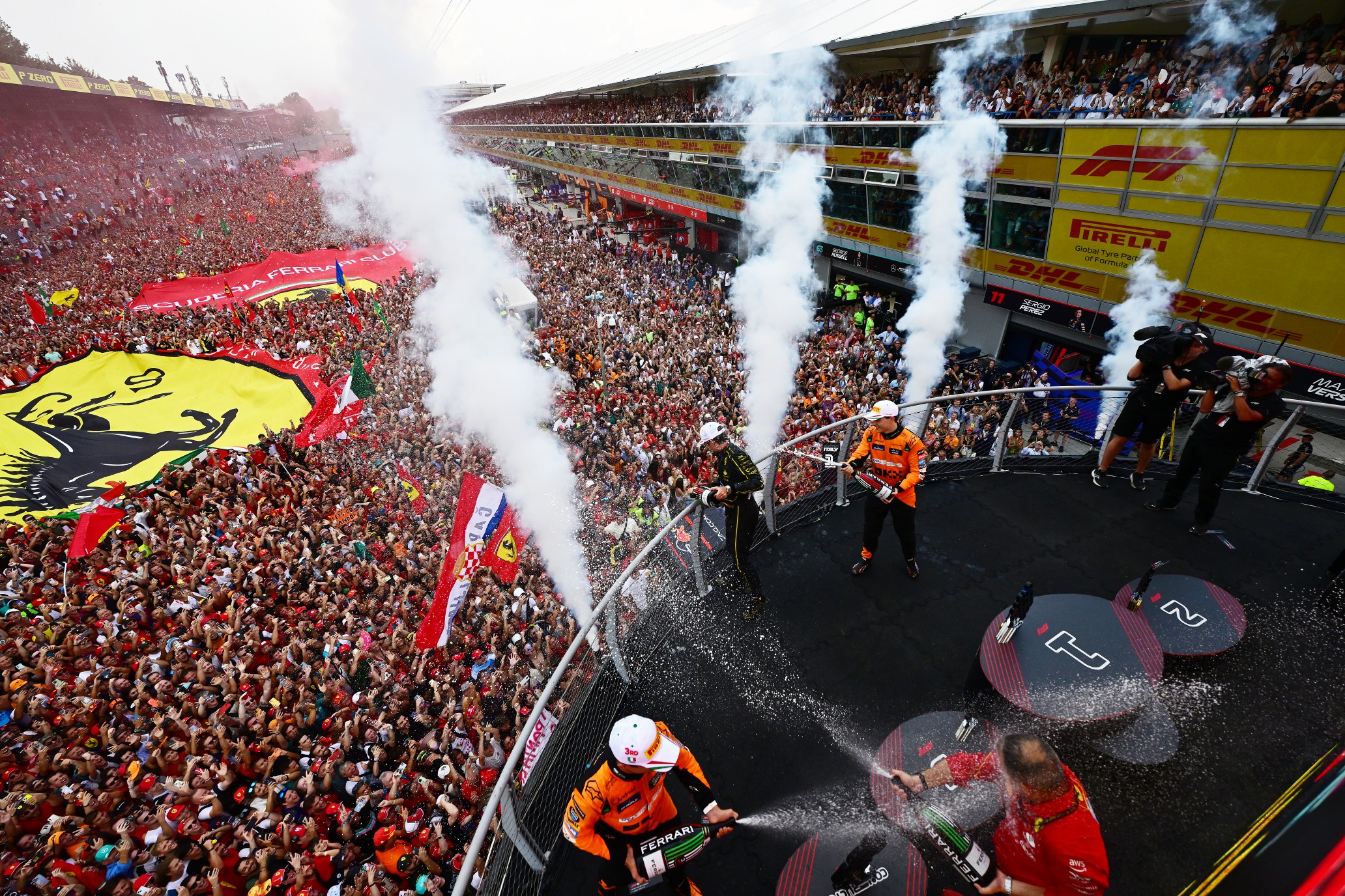 MONZA, ITALY - SEPTEMBER 01: A general view showing the podioum celebrations between Race winner Charles Leclerc of Monaco and Ferrari, Second placed Oscar Piastri of Australia and McLaren and Third placed Lando Norris of Great Britain and McLaren during the F1 Grand Prix of Italy at Autodromo Nazionale Monza on September 01, 2024 in Monza, Italy. (Photo by Mario Renzi - Formula 1/Formula 1 via Getty Images)