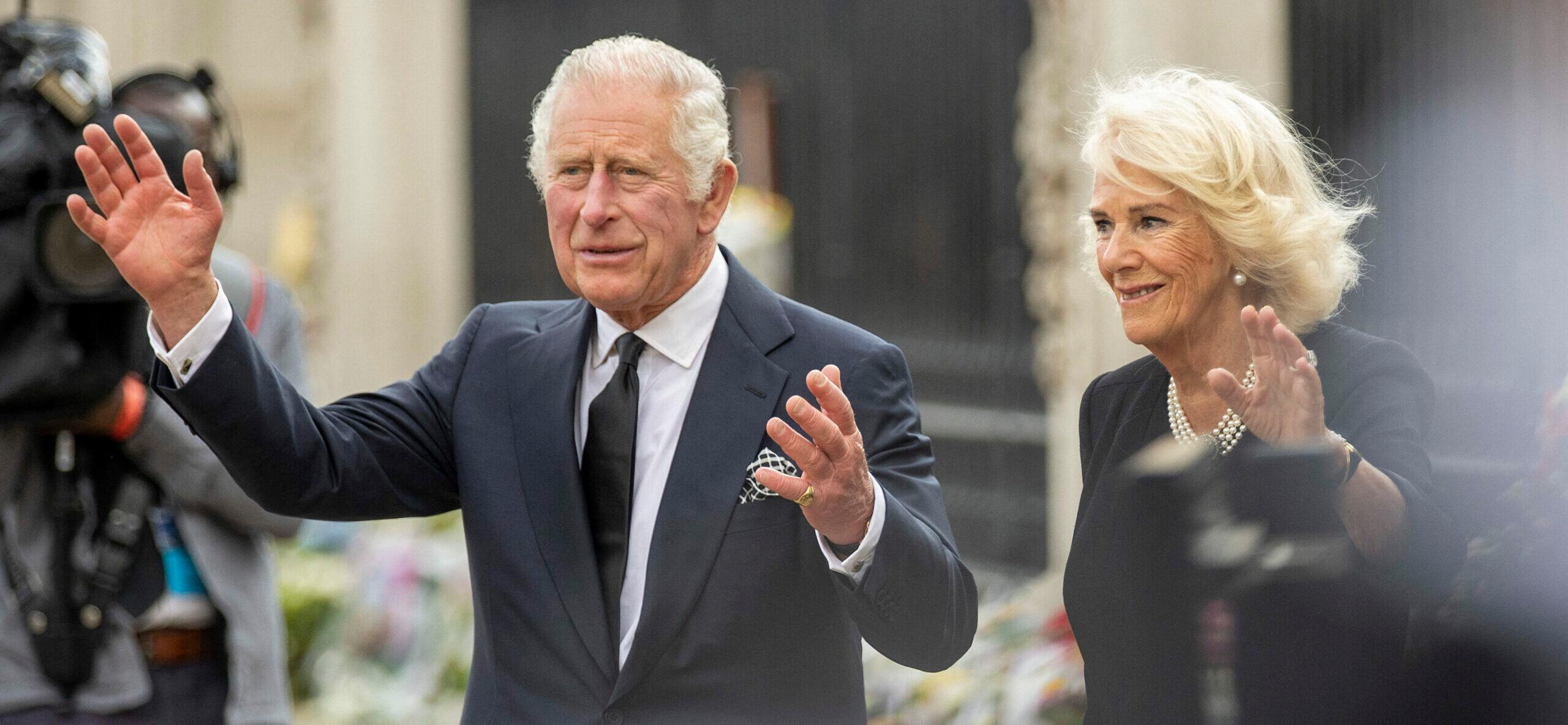 King Charles III and Queen Consort Camilla look at floral tributes left for Queen Elizabeth II outside Buckingham Palace in central London