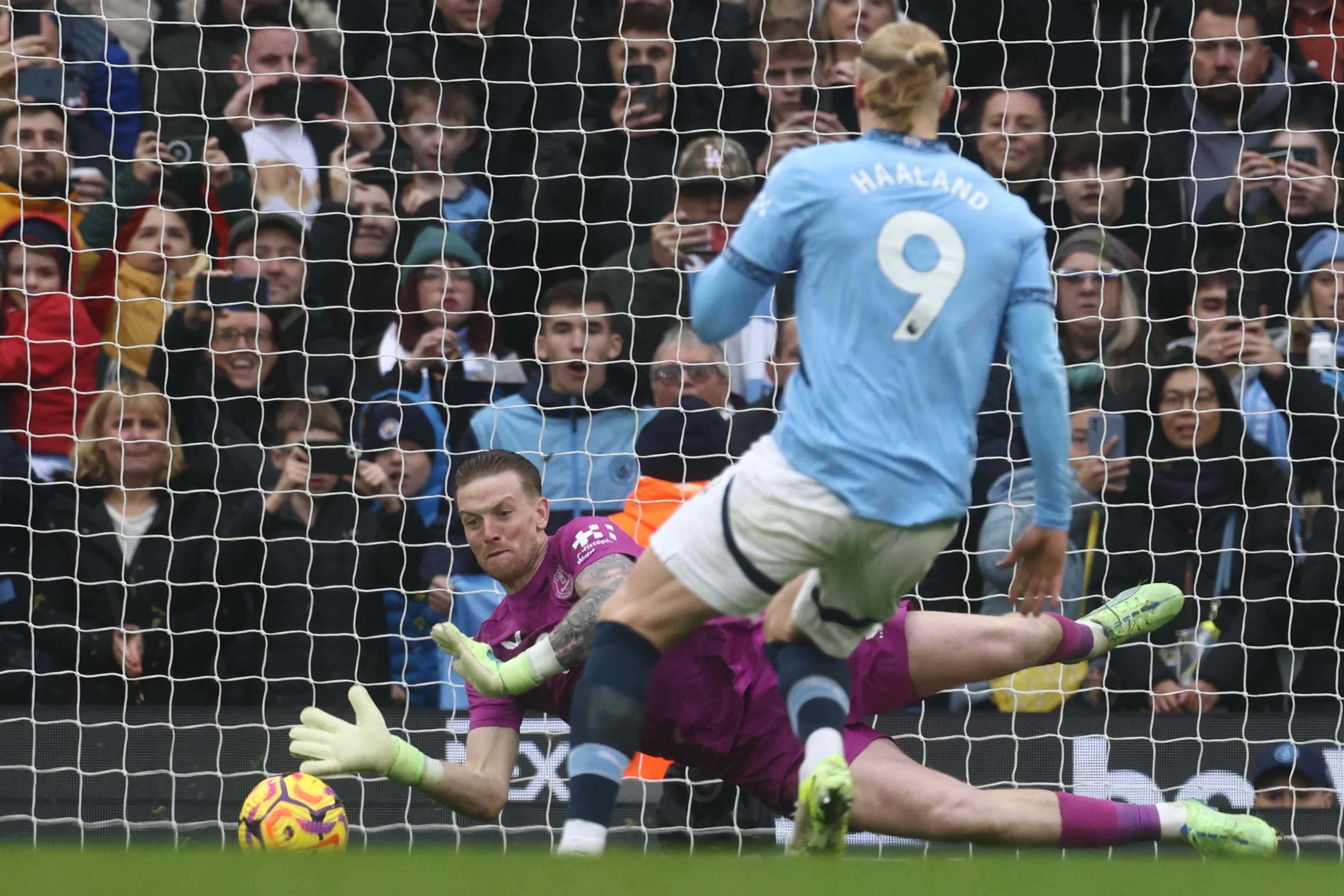 Everton's English goalkeeper #01 Jordan Pickford saves a penalty from Manchester City's Norwegian striker #09 Erling Haaland during the English Premier League football match between Manchester City and Everton at the Etihad Stadium in Manchester, north west England, on December 26, 2024. (Photo by Darren Staples / AFP) / RESTRICTED TO EDITORIAL USE. No use with unauthorized audio, video, data, fixture lists, club/league logos or 'live' services. Online in-match use limited to 120 images. An additional 40 images may be used in extra time. No video emulation. Social media in-match use limited to 120 images. An additional 40 images may be used in extra time. No use in betting publications, games or single club/league/player publications. / (Photo by DARREN STAPLES/AFP via Getty Images)
