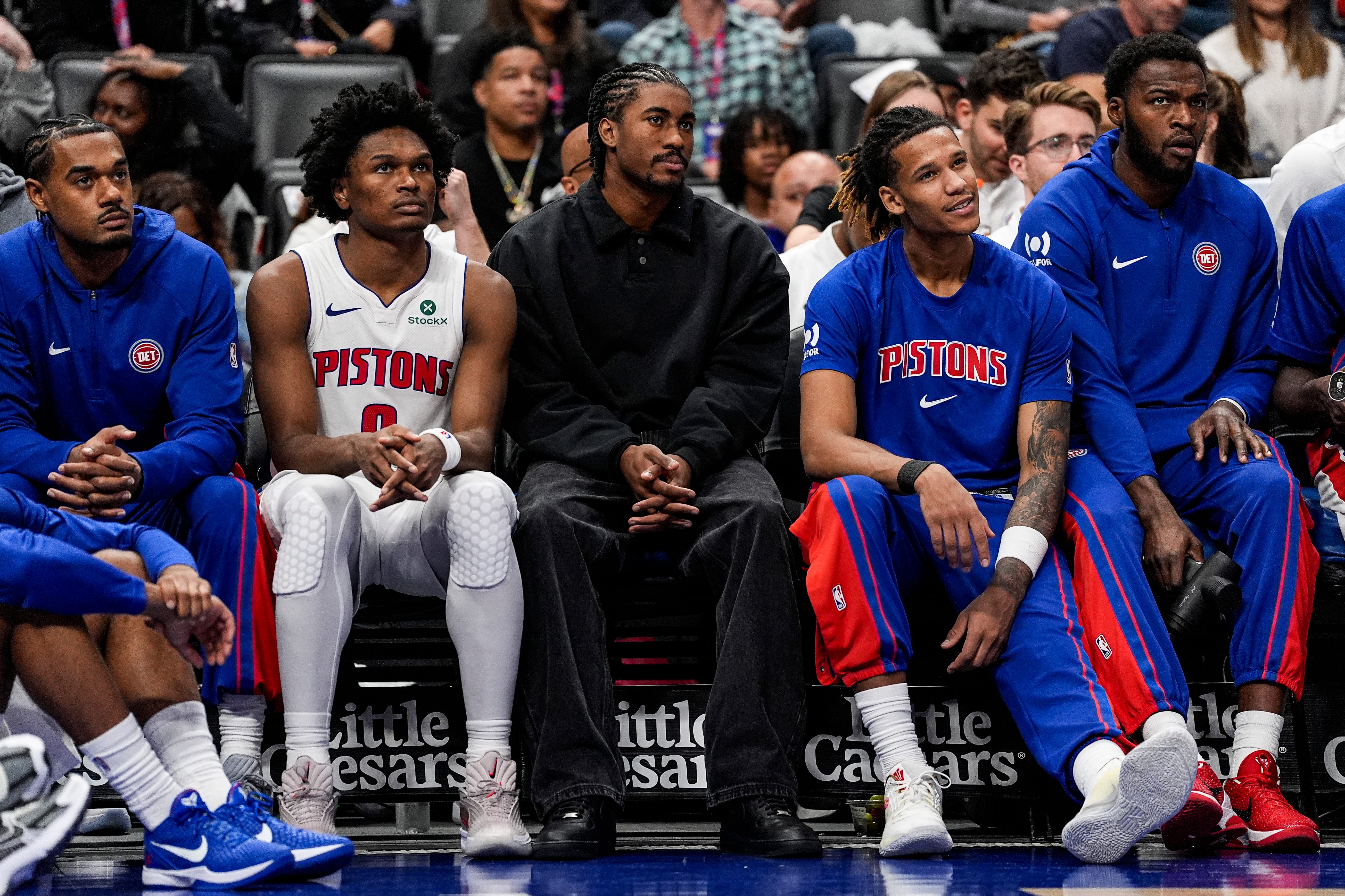 Detroit Pistons guard Jaden Ivey (23), center watches the game next to guard Ausar Thompson (9), left, and forward Bobi Klintman (34), right, during the second half against Boston Celtics at Little Caesars Arena in Detroit on Sunday, October 26, 2025.