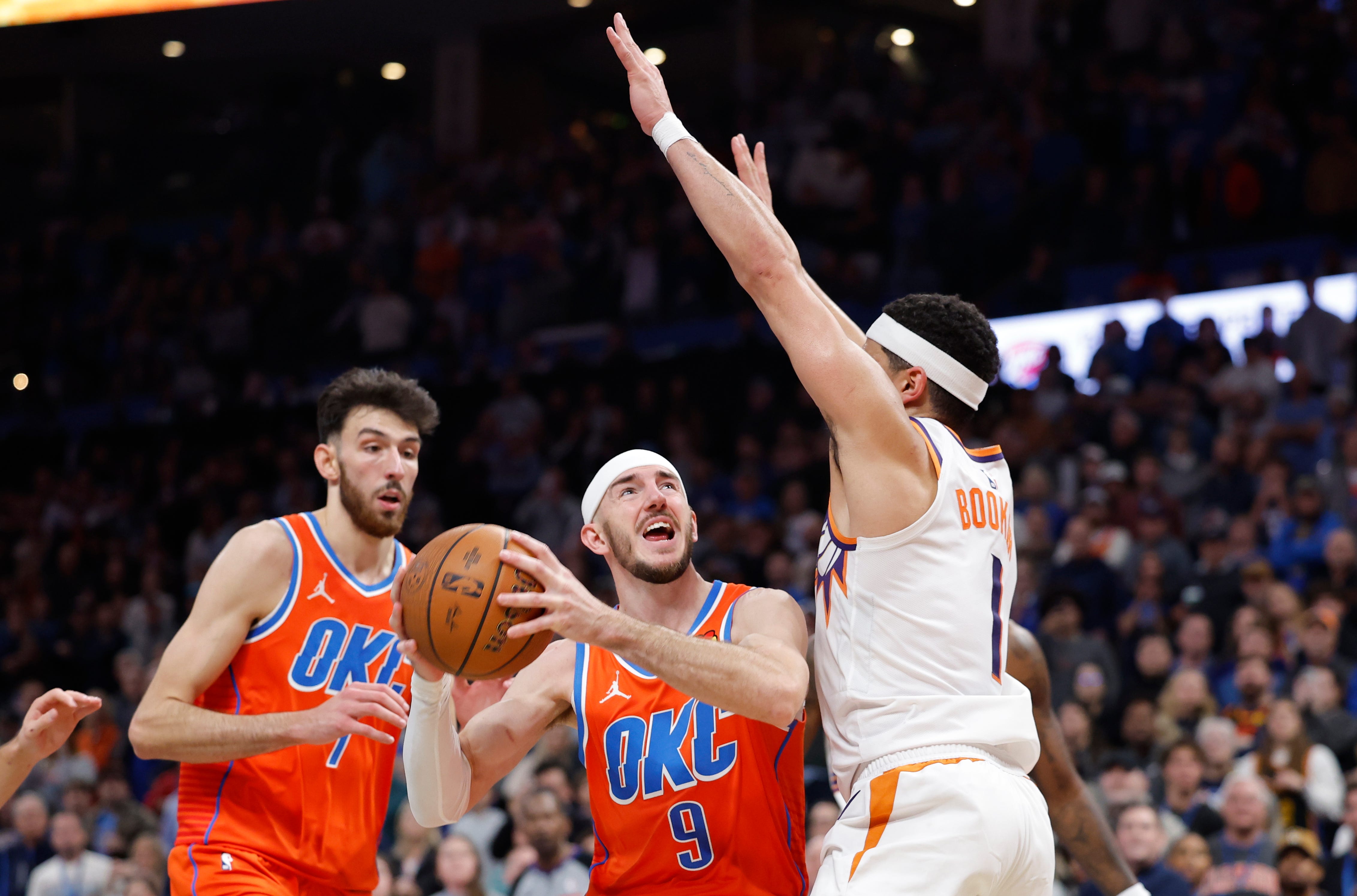 Nov 28, 2025; Oklahoma City, Oklahoma, USA; Oklahoma City Thunder guard Alex Caruso (9) attempts a shot as Phoenix Suns guard Devin Booker (1) defends during the second half at Paycom Center. Mandatory Credit: Alonzo Adams-Imagn Images