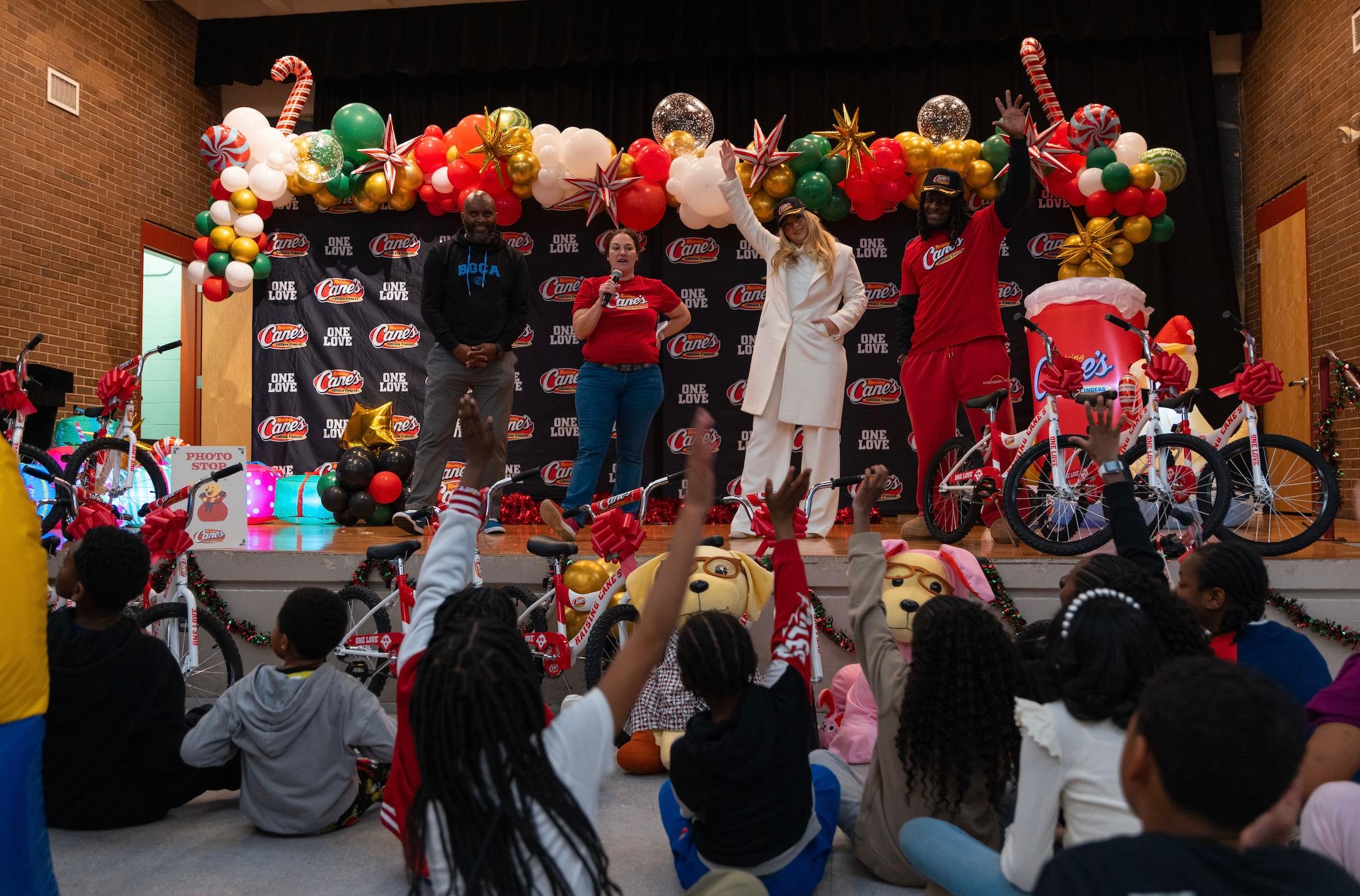 Camille Kostek, D'Ernest Johnson and Raising Cane's members at charity event