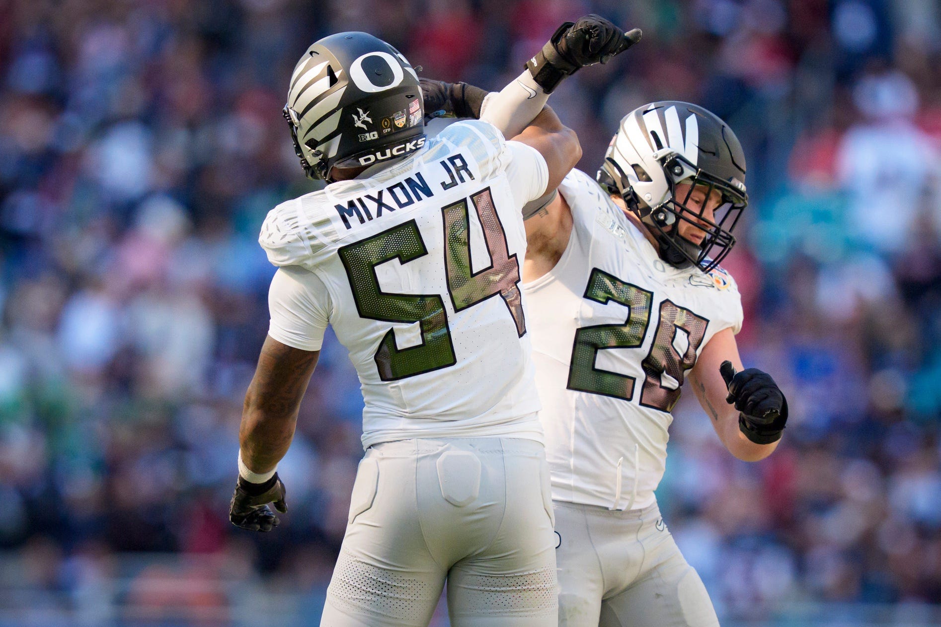Oregon inside linebackers Bryce Boettcher, right, and Jerry Mixon celebrate after a forced fumble as the Oregon Ducks take on the Texas Tech Red Raiders in the Orange Bowl on Jan. 1, 2026, at Hard Rock Stadium in Miami, Florida.
