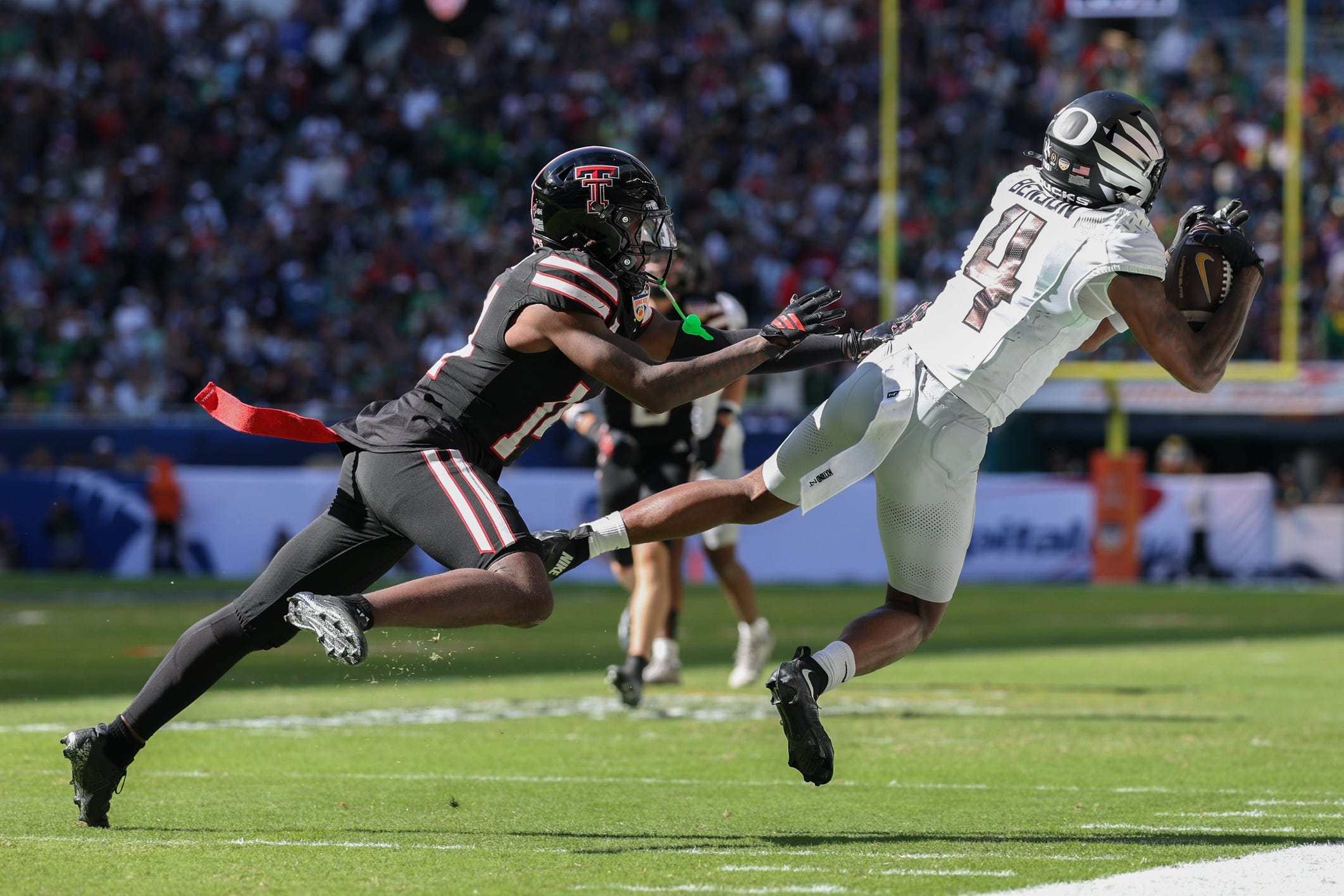Jan 1, 2026; Miami Gardens, FL, USA; Oregon Ducks wide receiver Malik Benson (4) makes the catch in front of Texas Tech Red Raiders defensive back Brice Pollock (14) during the first half of the 2025 Orange Bowl and quarterfinal game of the College Football Playoff at Hard Rock Stadium. Mandatory Credit: Nathan Ray Seebeck-Imagn Images
