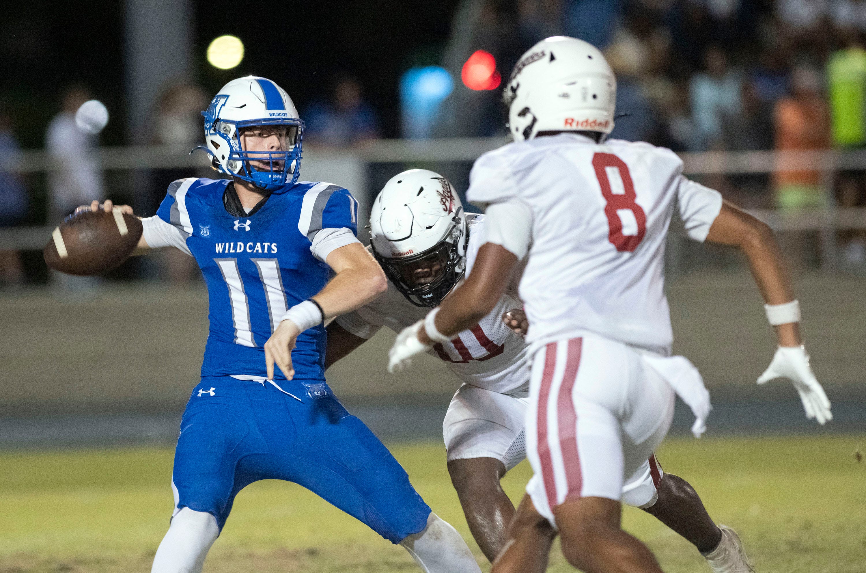 Washington quarterback Caden Osborn (No. 11) gets flushed out of the pocket by Tate's Maliek North (No. 8) and John Flynn (10) for a loss of yards during Friday night's District 1-6A football game.