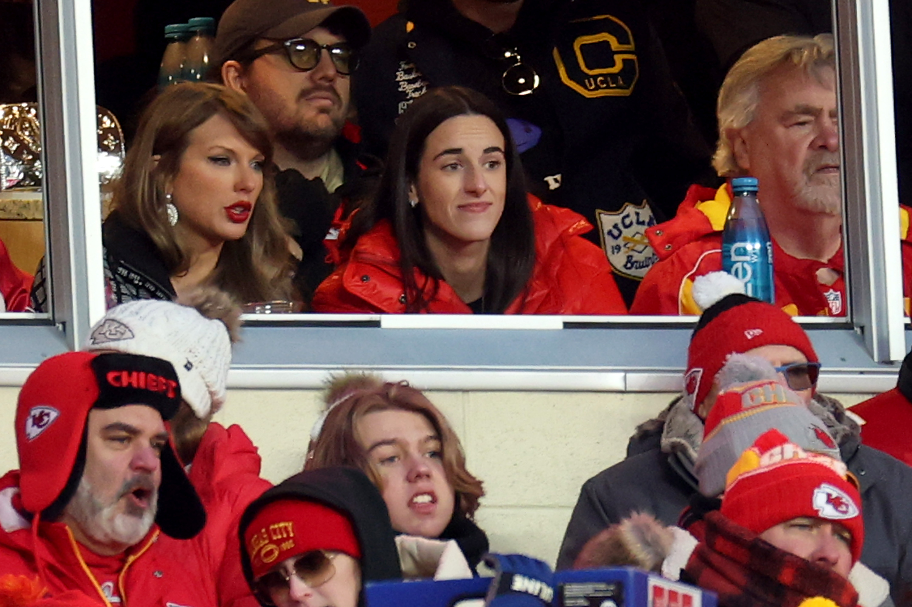 KANSAS CITY, MISSOURI - JANUARY 18: Singer-songwriter Taylor Swift (L) talks with Caitlin Clark (R) of the Indiana Fever during the second half in the AFC Divisional Playoff between the Houston Texans and the Kansas City Chiefs at GEHA Field at Arrowhead Stadium on January 18, 2025 in Kansas City, Missouri. (Photo by Jamie Squire/Getty Images)