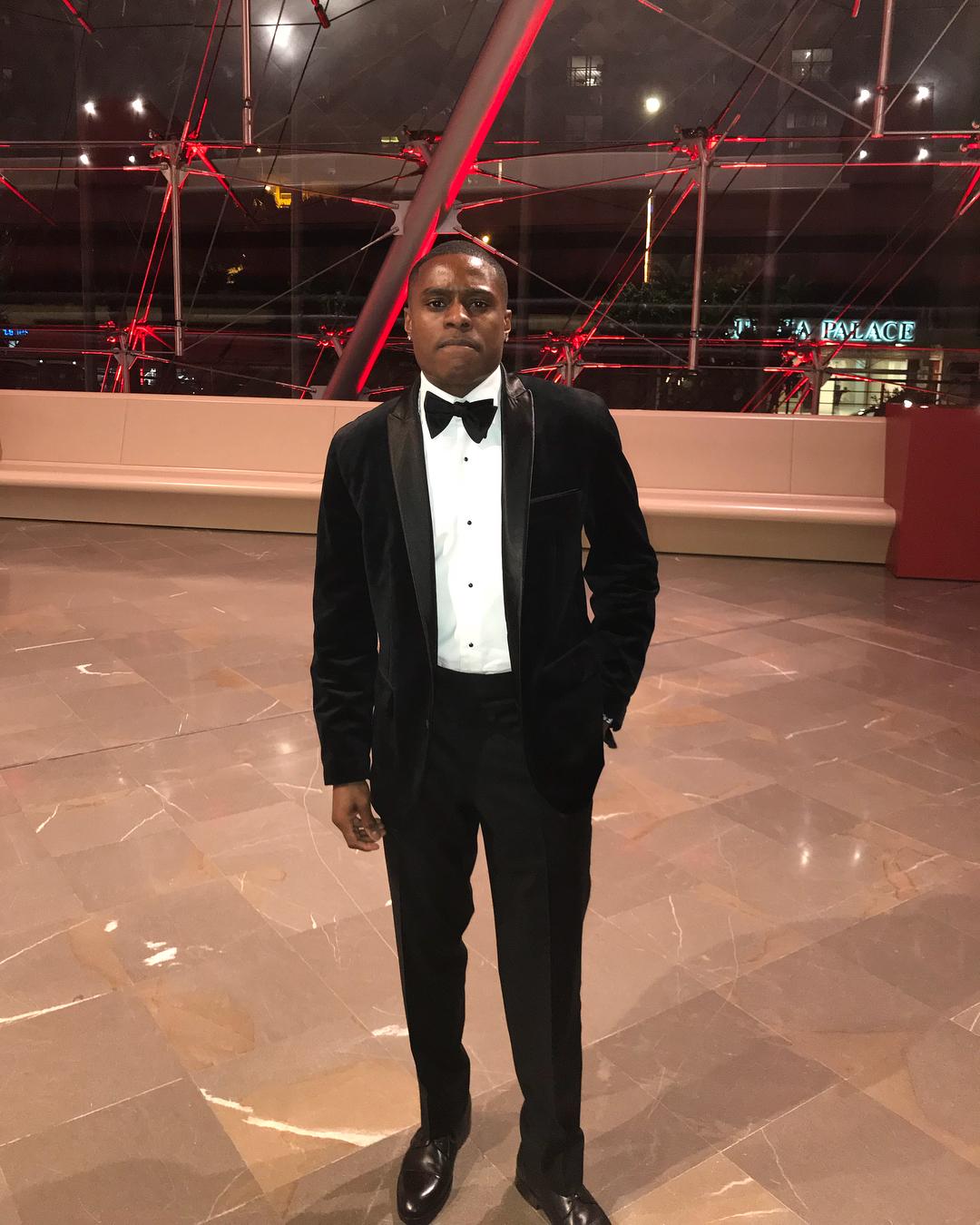 Christian Coleman posing in a suit. 