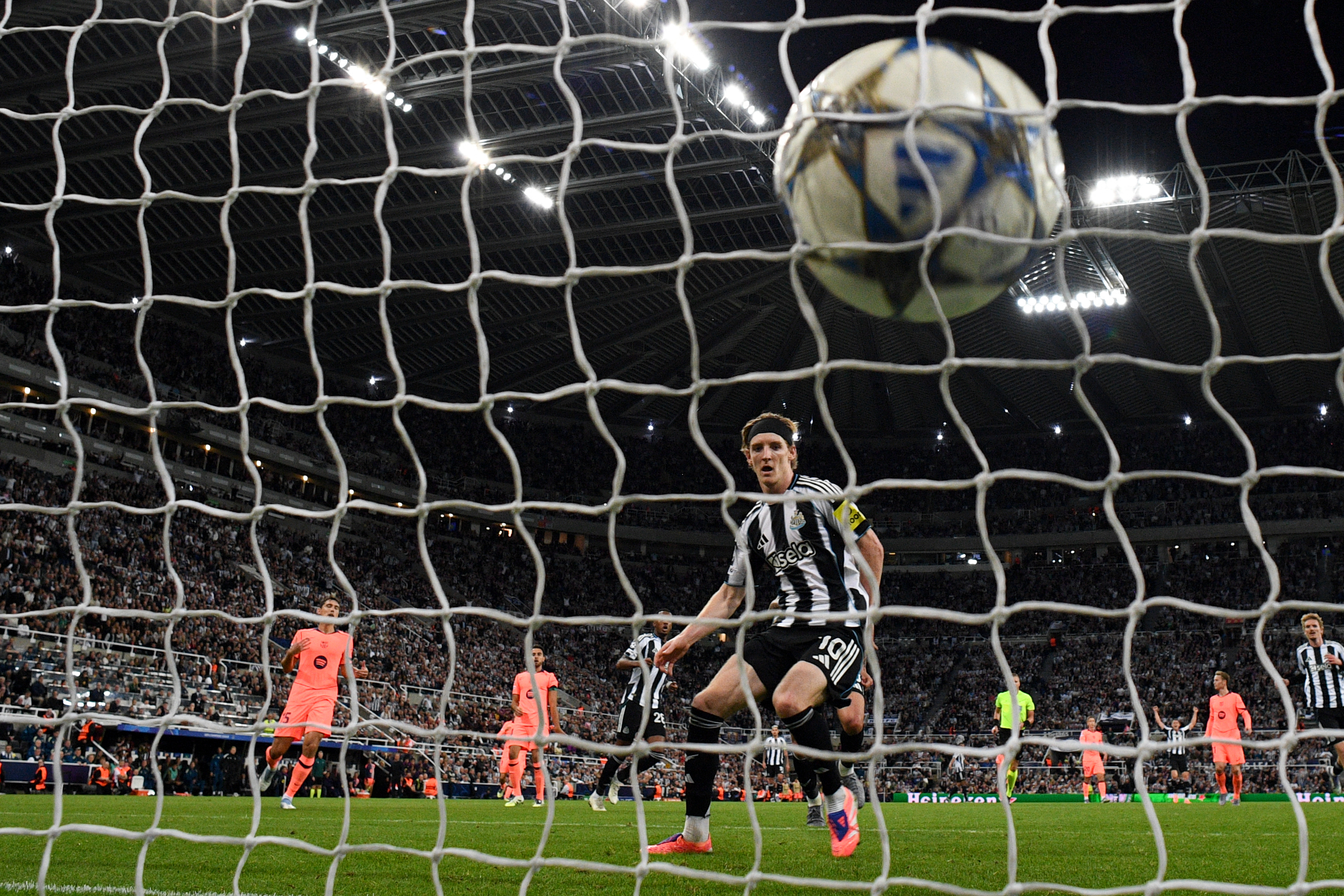 TOPSHOT - Newcastle's British forward #10 Anthony Gordon shoots to score his team's first goal during the UEFA Champions League first round football match between Newcastle United FC and FC Barcelona at St James' Park in Newcastle, on September 18, 2025. (Photo by Oli SCARFF / AFP)
