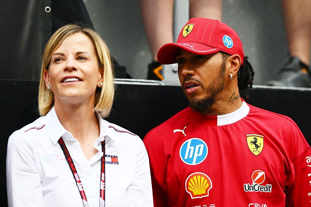 Susie Wolff wears a white shirt whilst Lewis Hamilton is pictured in a red Ferrari cap and race suit.