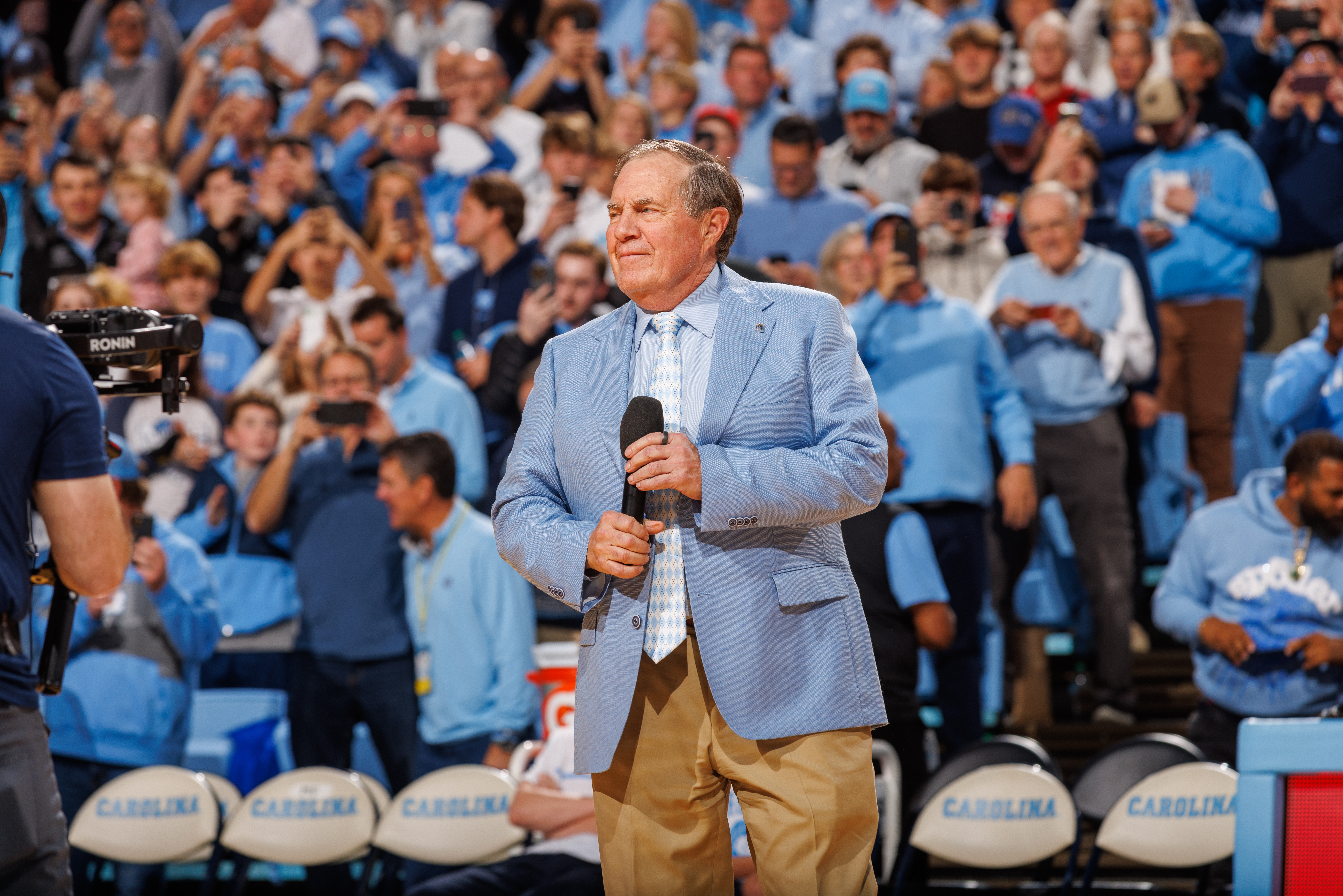 CHAPEL HILL, NORTH CAROLINA - DECEMBER 14: North Carolina Tar Heels football head coach Bill Belichick speaks to the crowd during a basketball game against the La Salle Explorers at Dean E. Smith Center on December 14, 2024 in Chapel Hill, North Carolina. North Carolina won 93-67. (Photo by Peyton Williams/UNC/Getty Images)