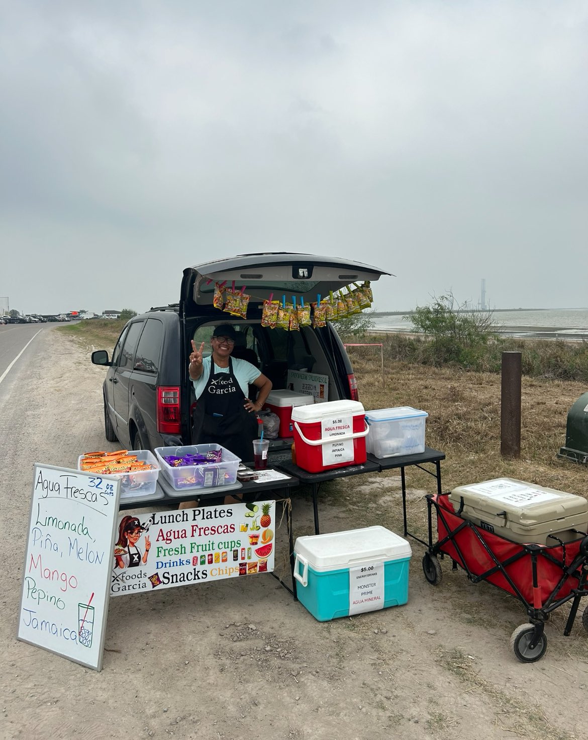 A woman selling food at the side of the road.