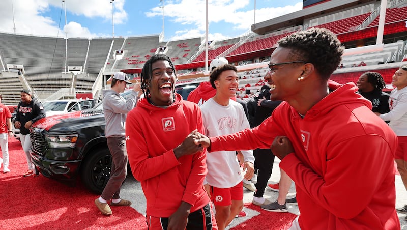 Utah Utes Daidren Zipperer, left, and C.J. Blocker celebrate getting a Dodge truck given to each player on the team by the Crimson Collective during an NIL announcement at Rice-Eccles Stadium in Salt Lake City on Wednesday, Oct. 4, 2023.