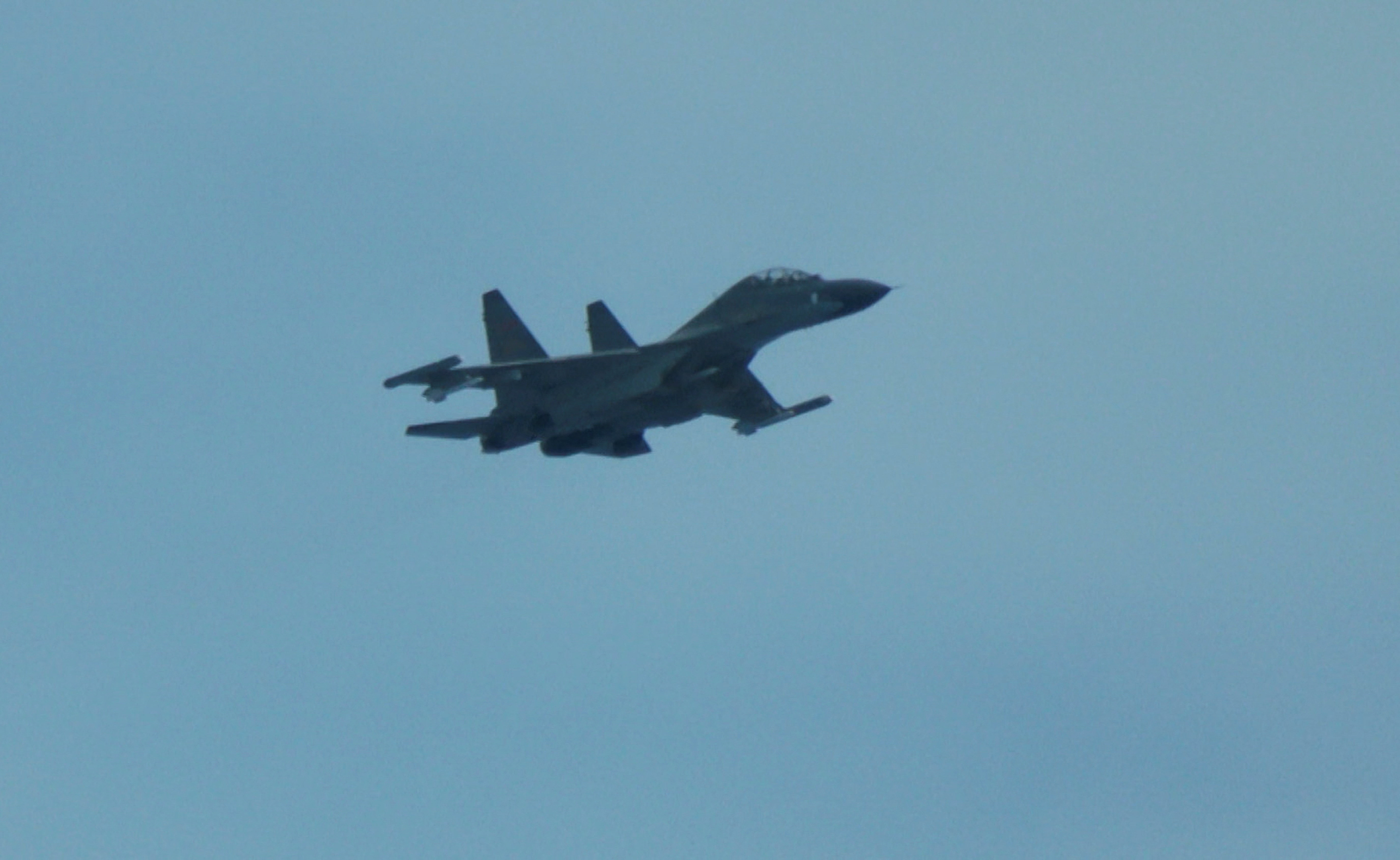An aerial view of a Chinese fighter jet flying close to a Philippine Coast Guard aircraft carrying journalists during a patrol flight, days after two Chinese vessels collided in the area while allegedly trying to block a Philippine supply mission, over the disputed Scarborough Shoal in the South China Sea, August 13, 2025. REUTERS/Adrian Portugal
